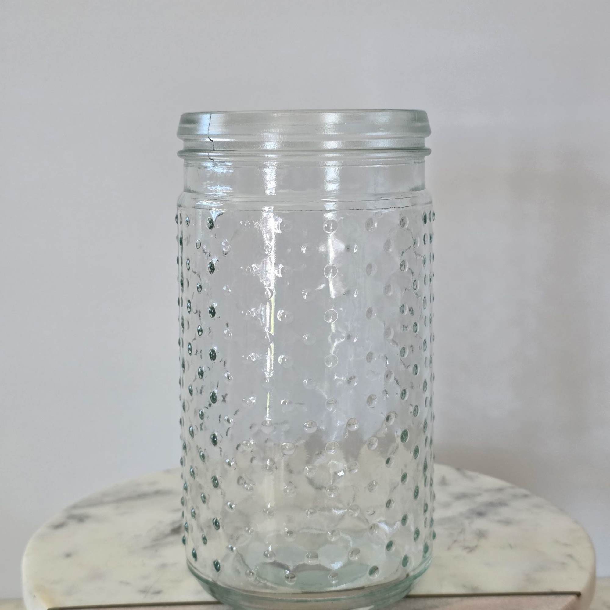 Clear textured glass jar with a metal lid