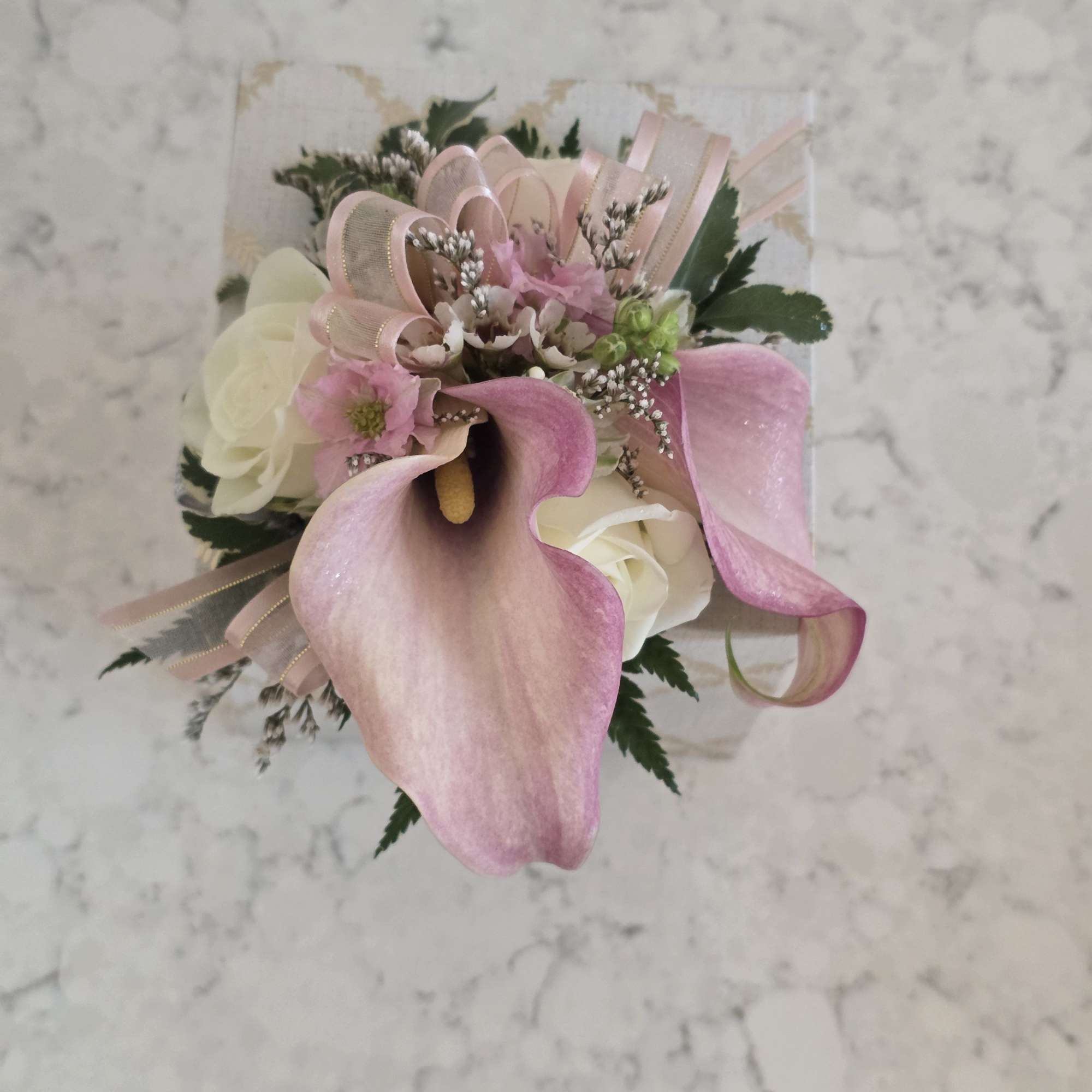 A delicate pairing of mini calla lilies, and roses makes this prom