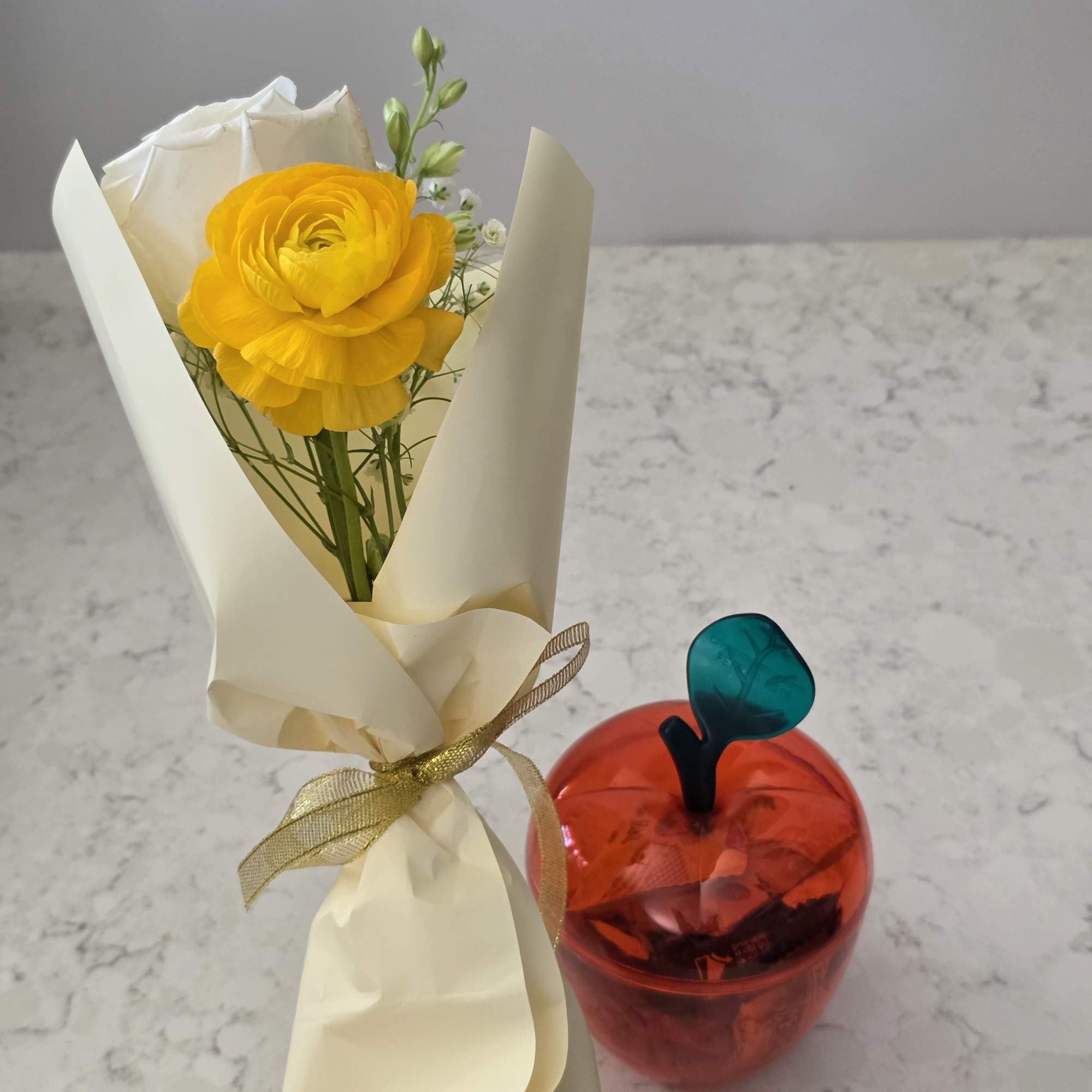 A bright yellow ranunculus paired with a creamy white rose makes this