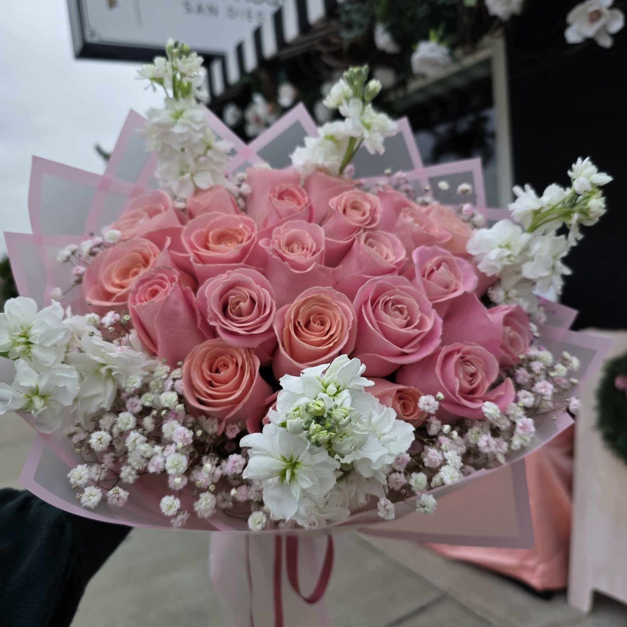A rounded cluster of soft pink roses forms the heart of this