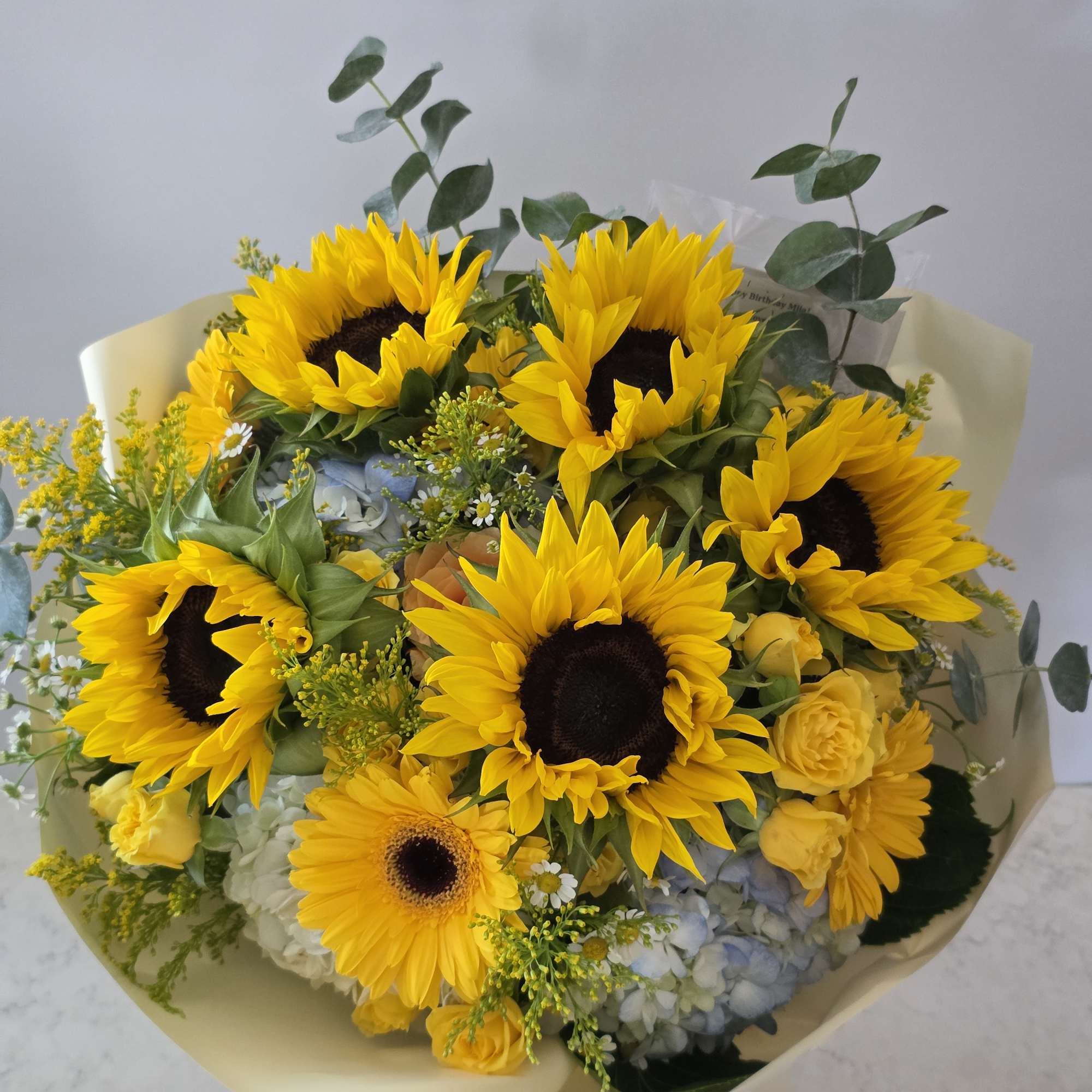 Bouquet of sunflowers with yellow roses and blue hydrangeas