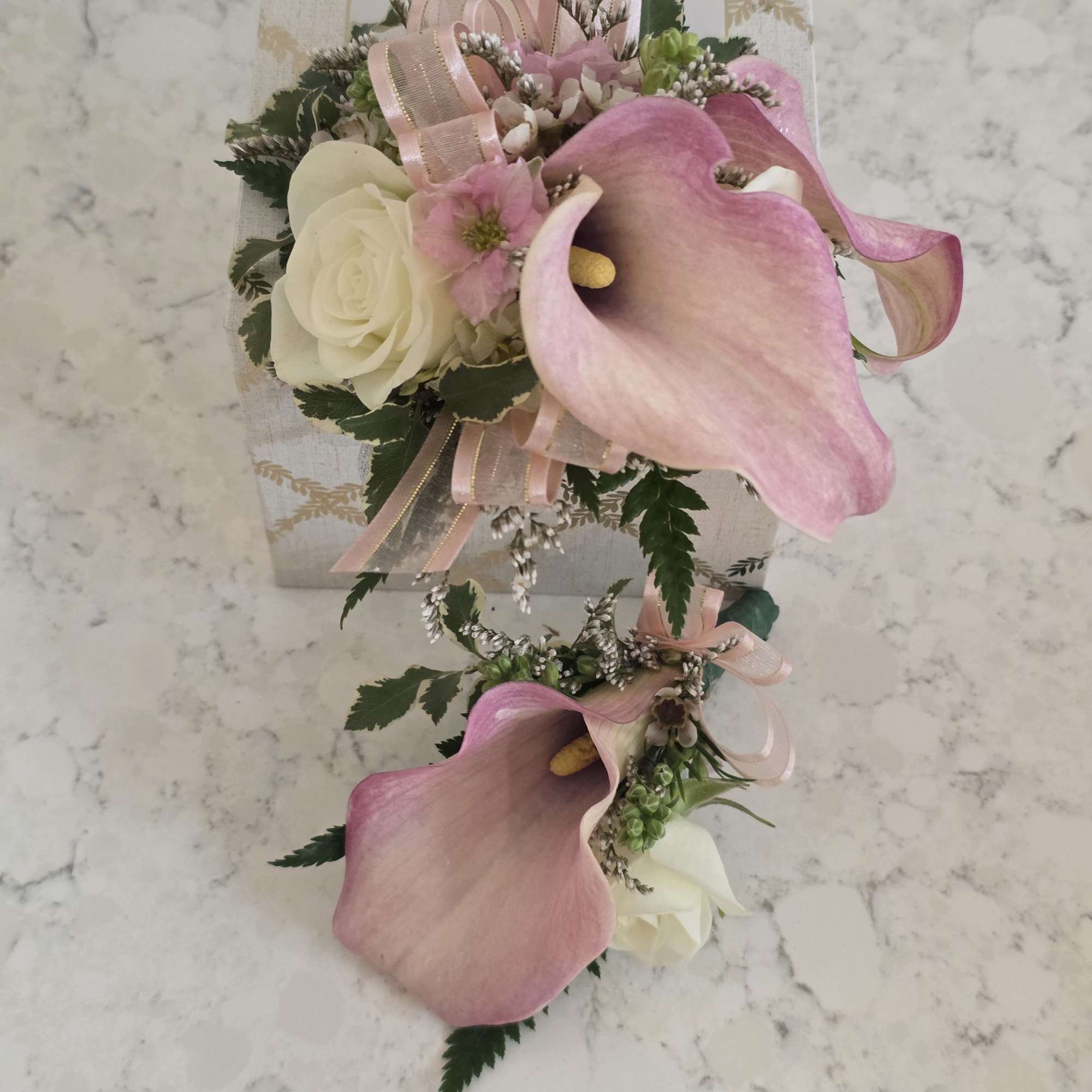 A delicate pairing of mini calla lilies, and roses makes this prom