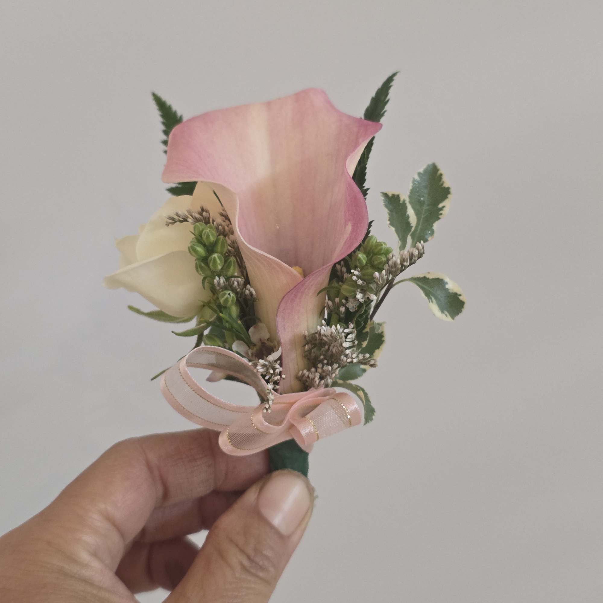 A delicate pairing of mini calla lilies, and roses makes this prom