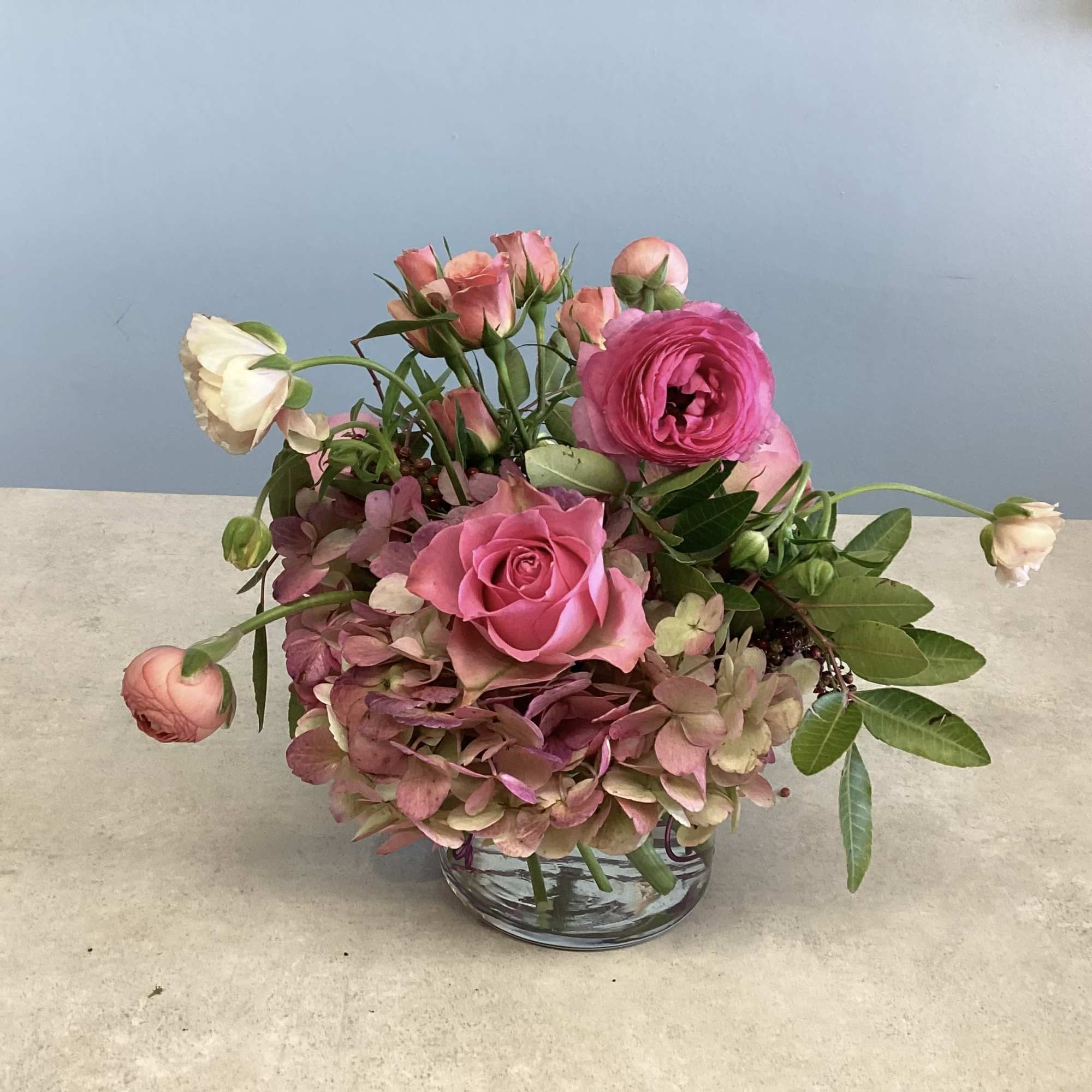 A compact garden-style arrangement in soft pinks, peaches and fresh green, Meadow