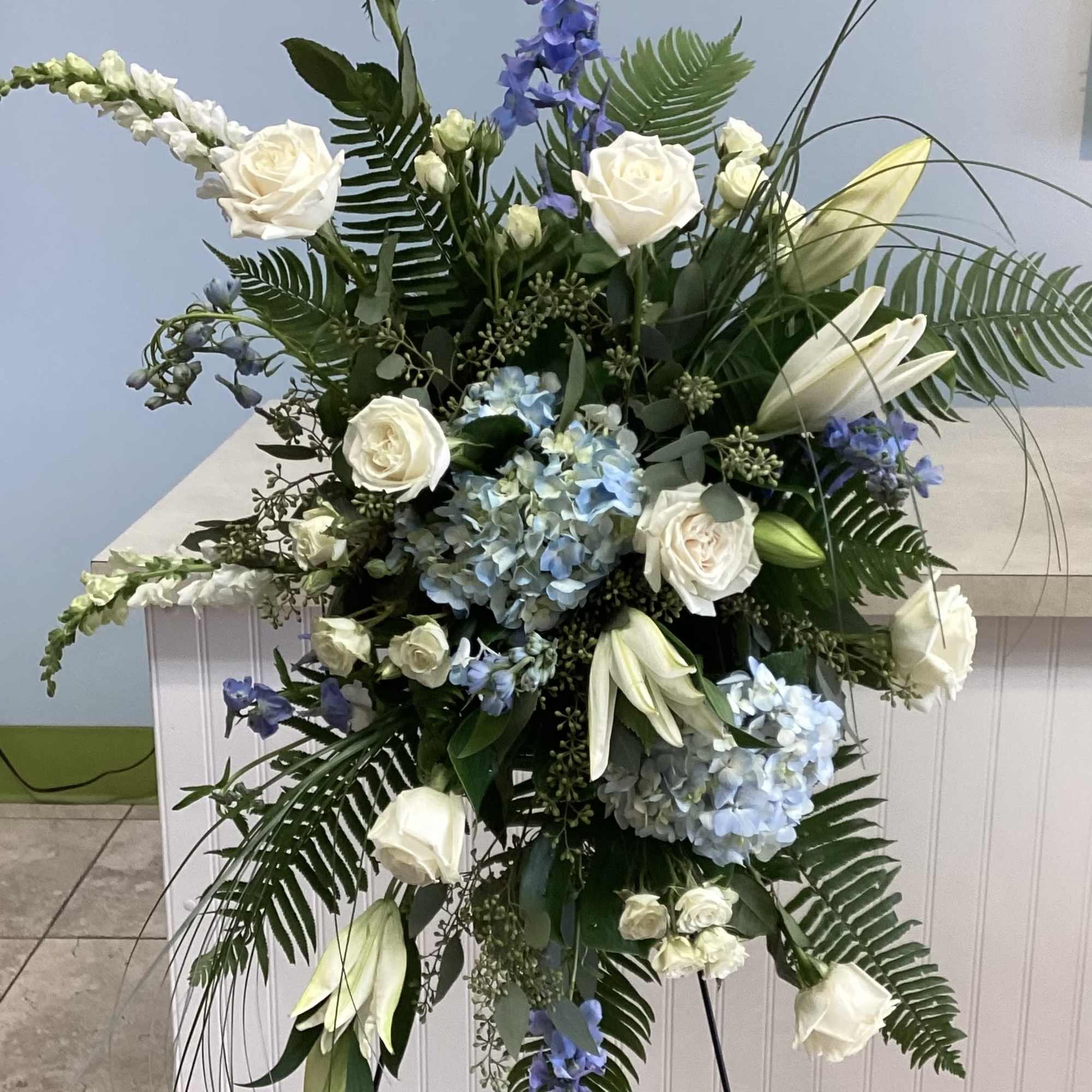 White and blue standing spray of roses, hydrangeas, lilies and delphinium with, photo 2 of 2