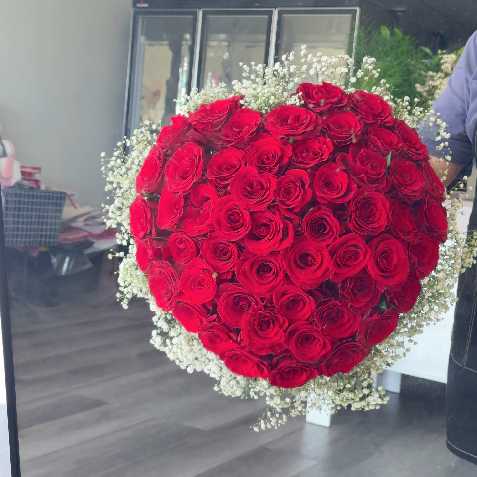 Large heart-shaped bouquet of red roses with white baby's breath