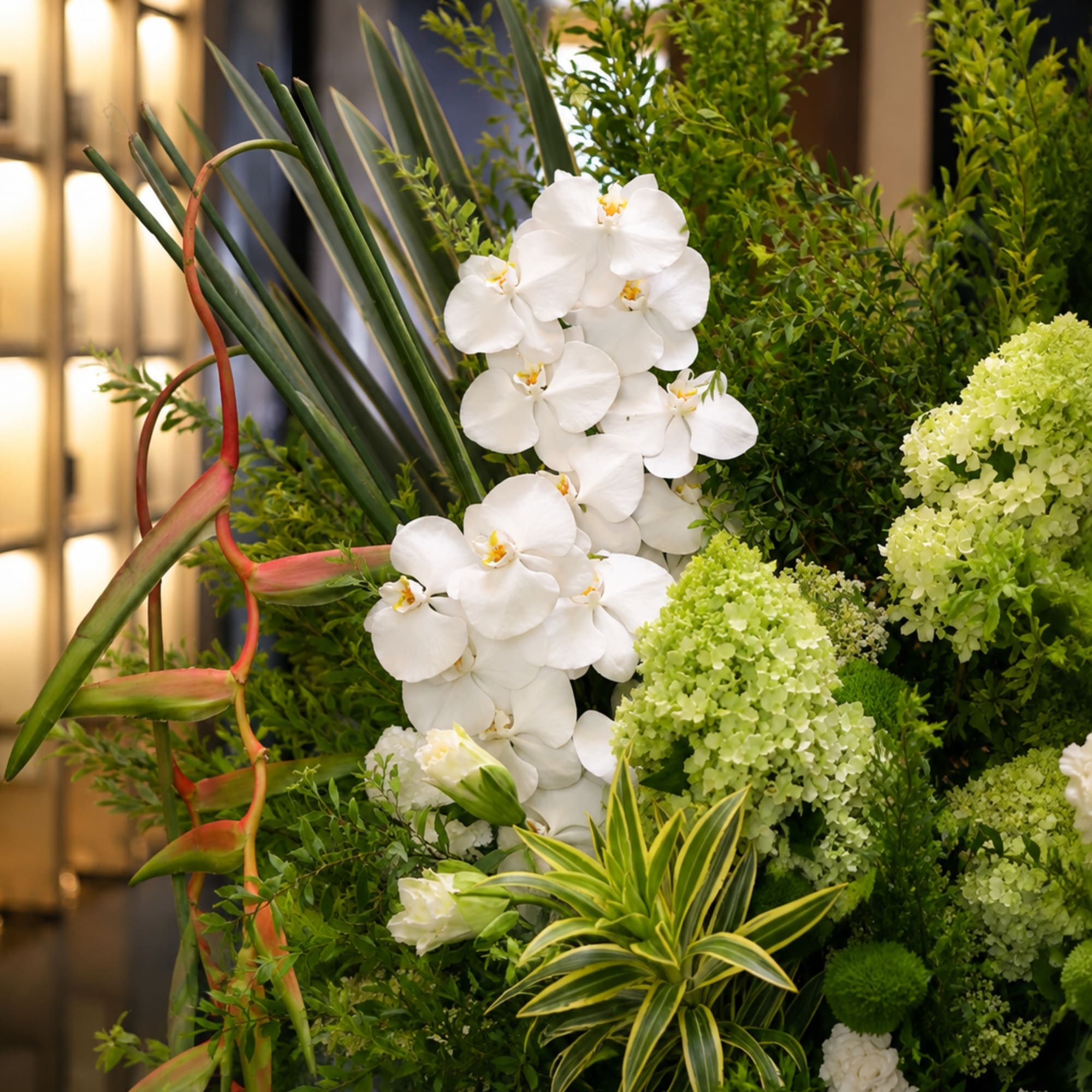 Tall floral arrangement with white orchids and green hydrangeas