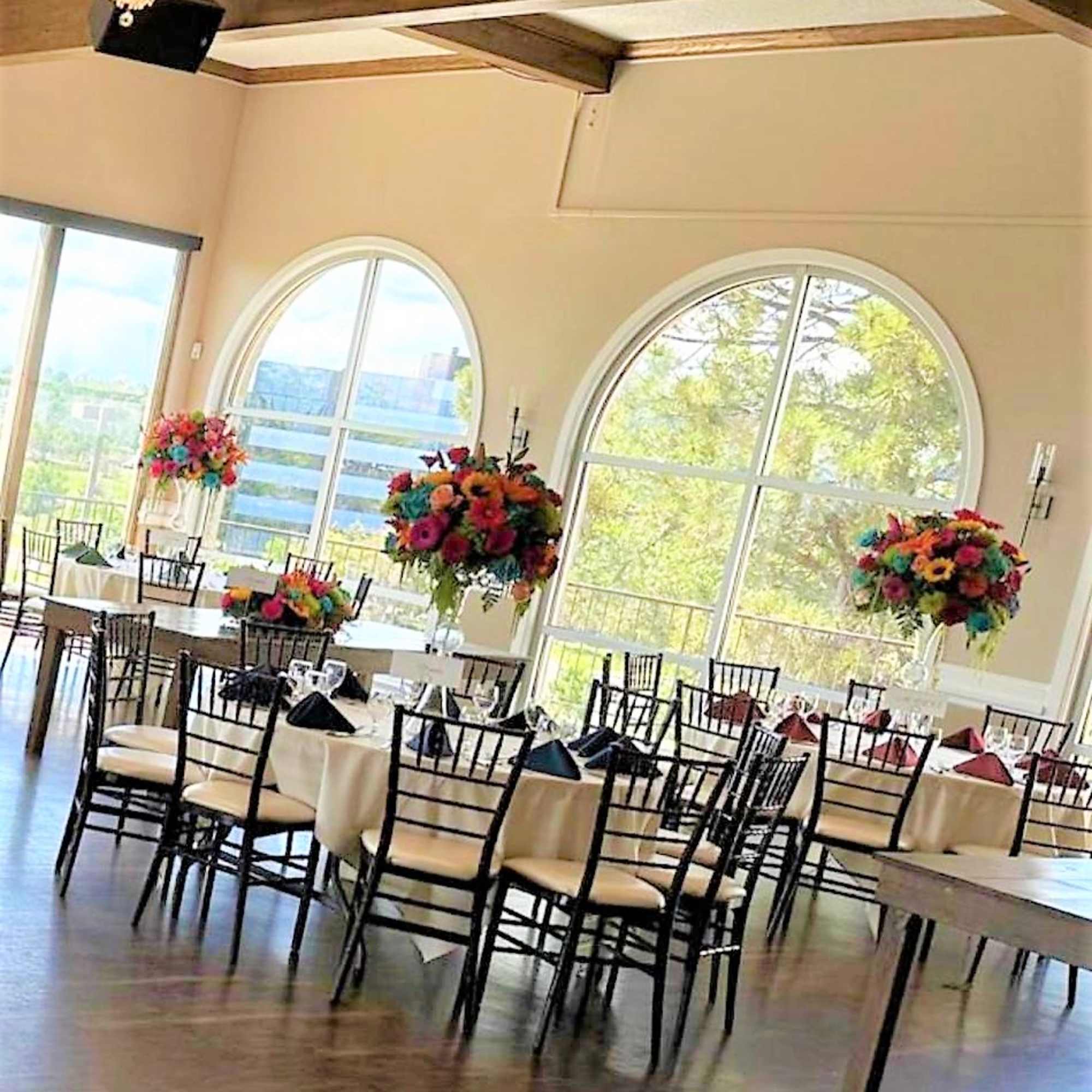 Colorful floral centerpieces on tall stands in a banquet room
