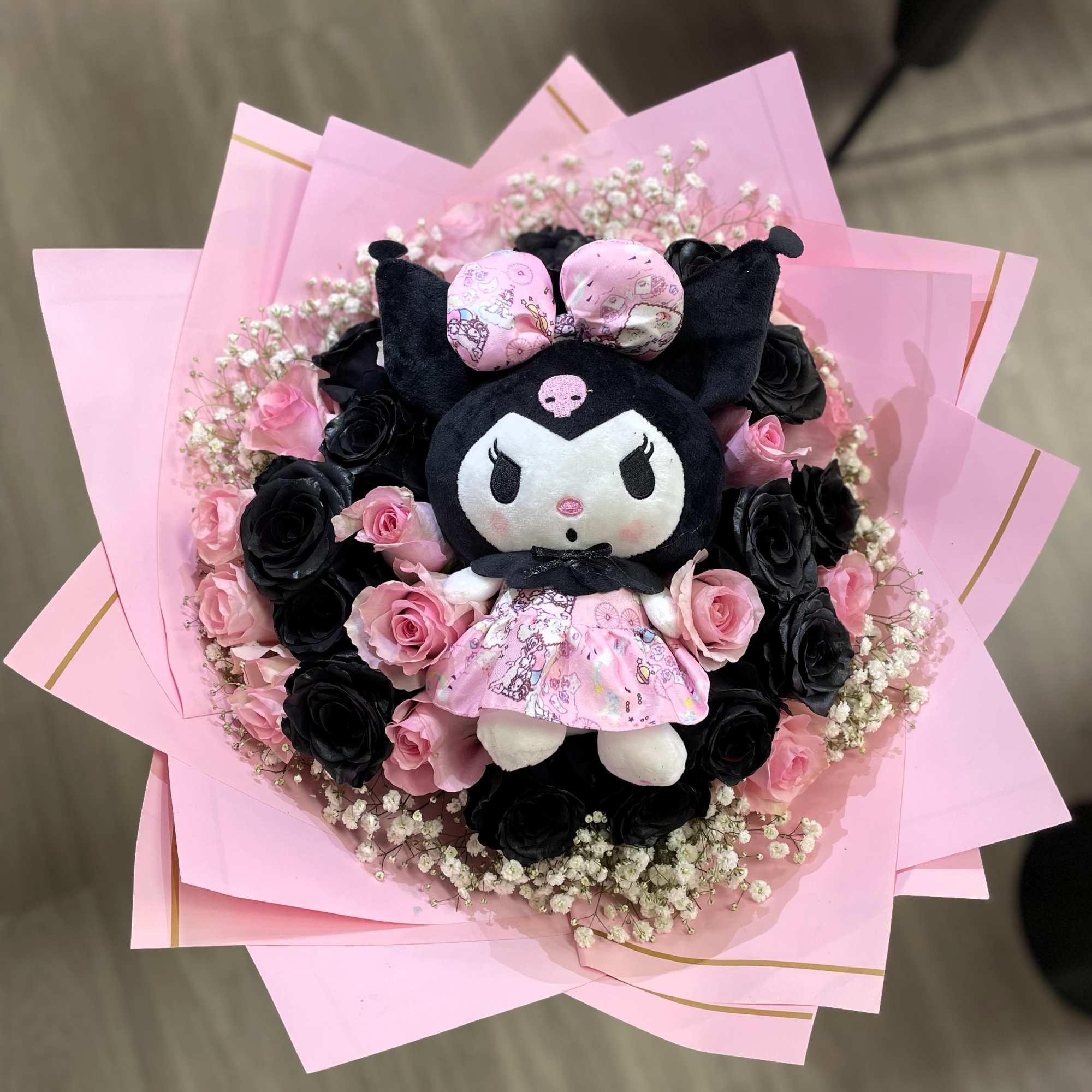 Pink and black rose bouquet with a plush character in the center