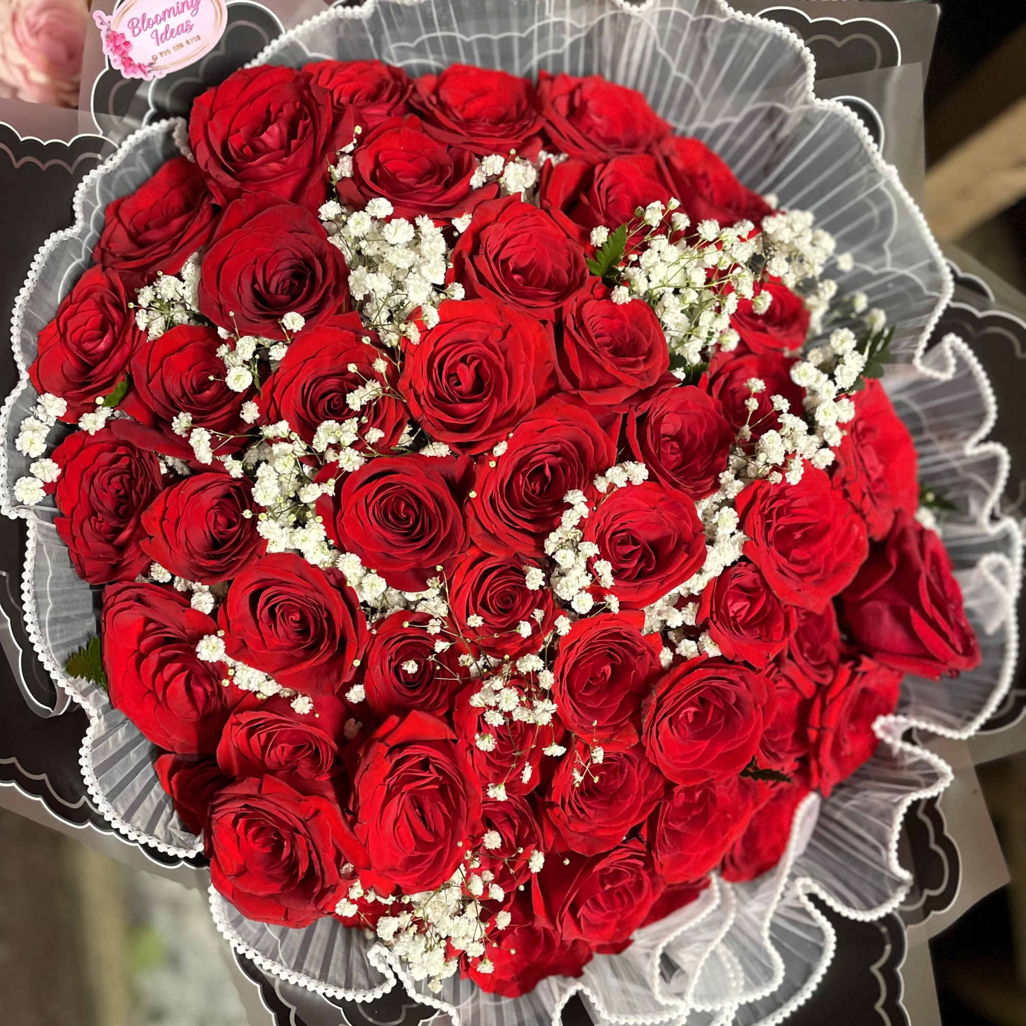 Bouquet of red roses with white baby's breath in gray wrapping