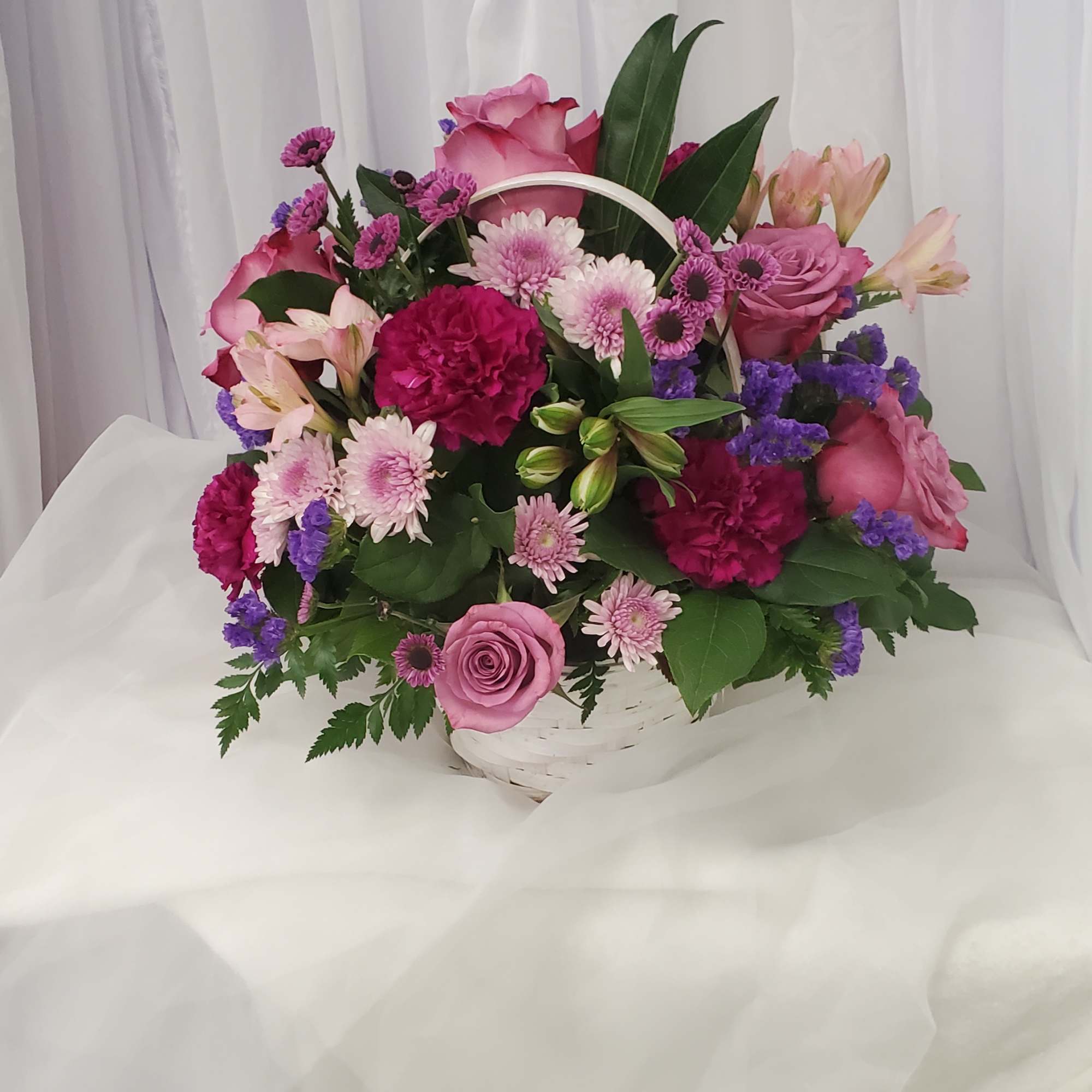 Pink and purple mixed flower basket with roses and daisies