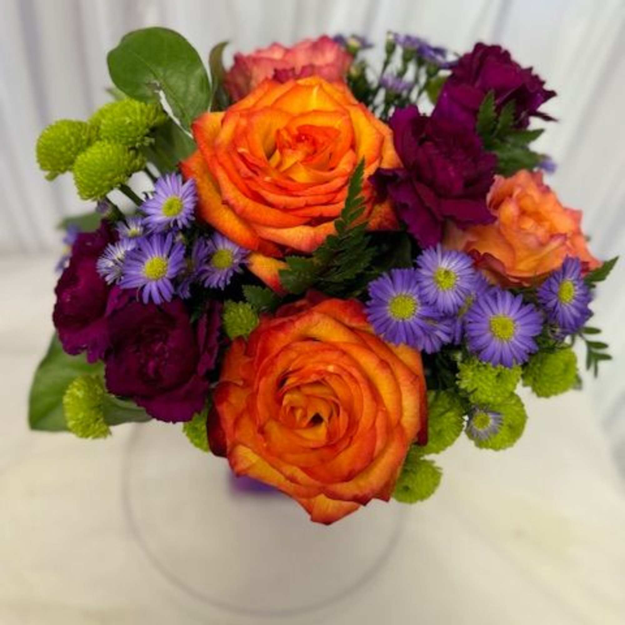 Bouquet of orange and purple flowers in a clear vase