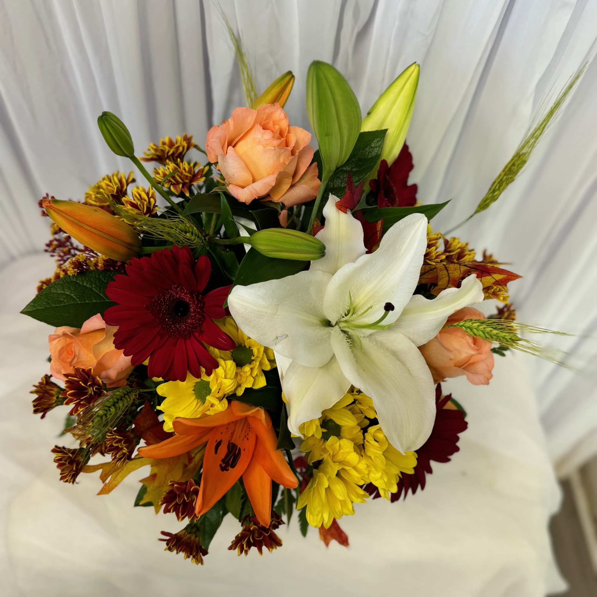 Mixed bouquet with white lily, peach roses, and red gerbera daisies