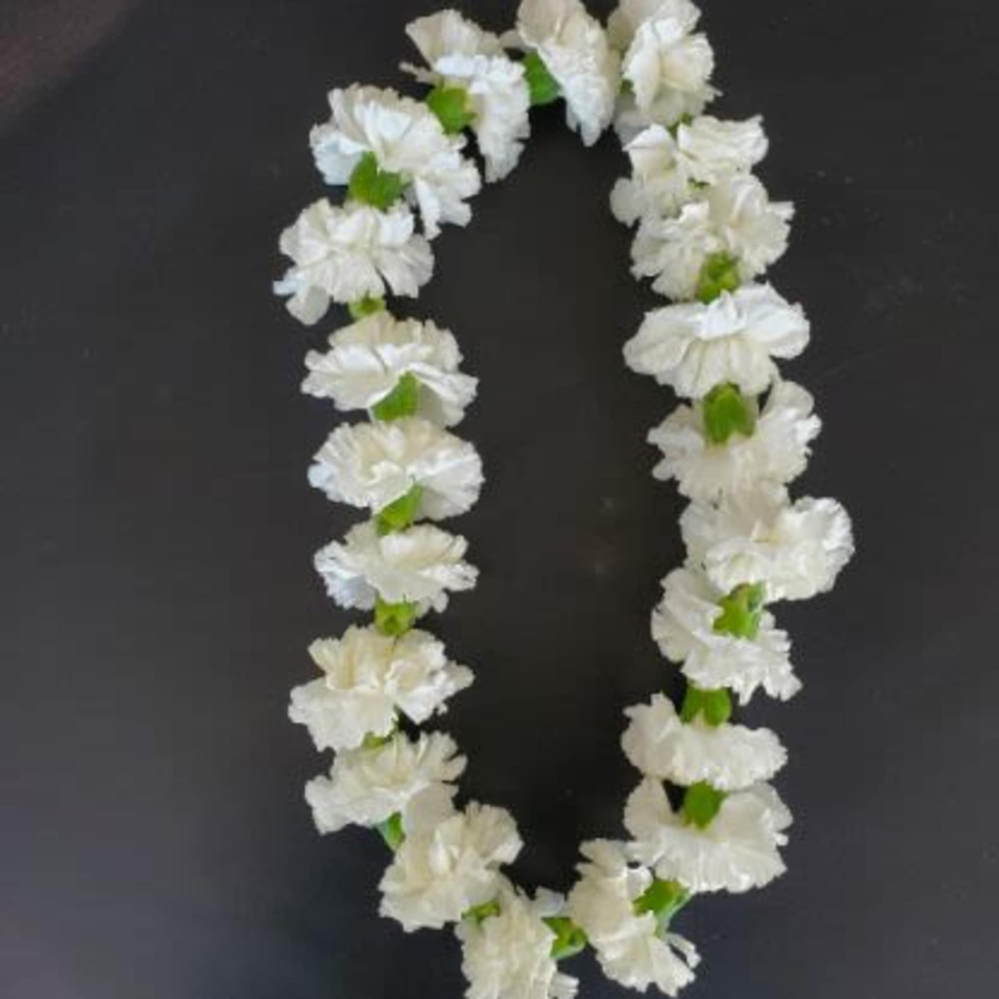 White flower lei on a dark background