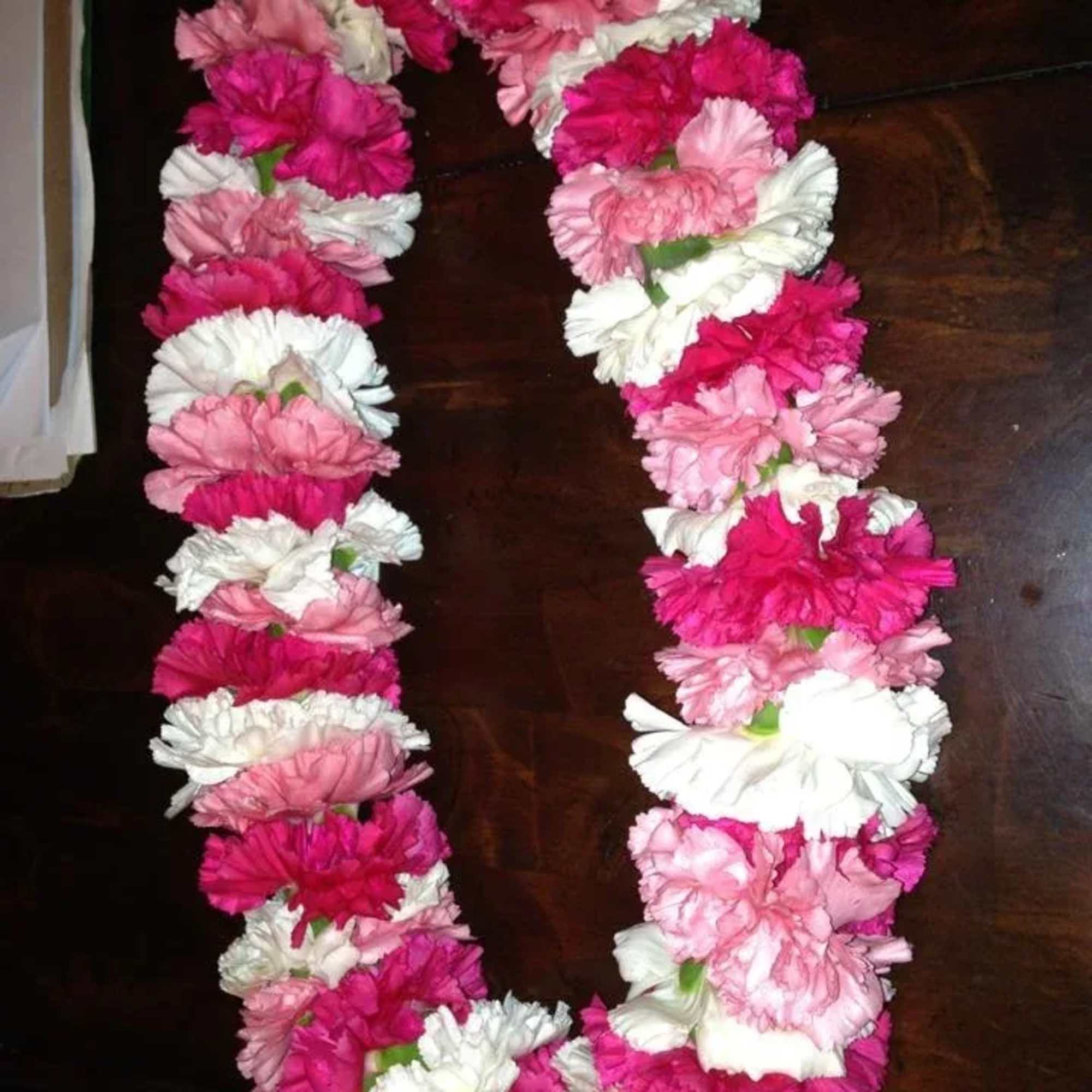 Pink and white flower lei arranged in a U shape