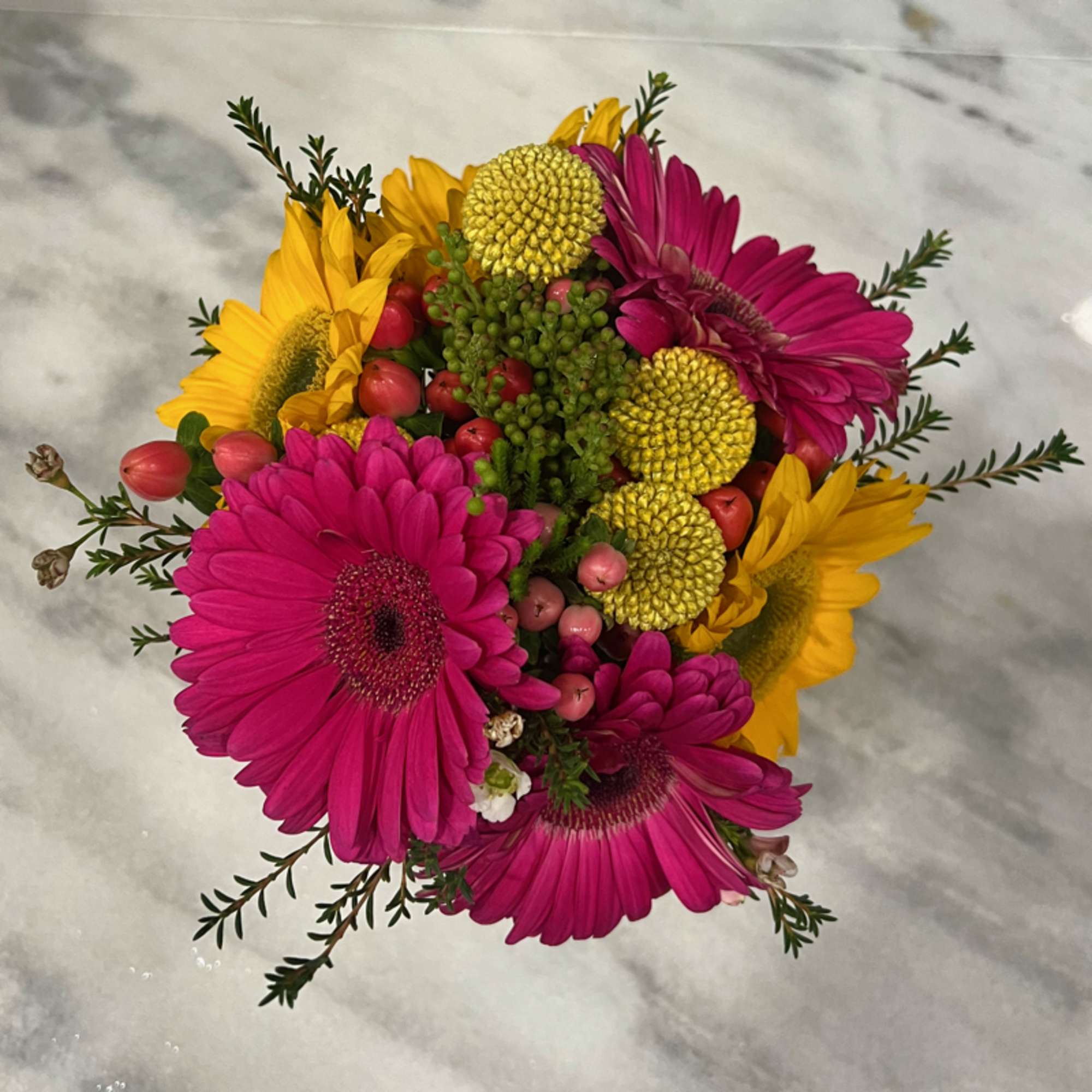 Bouquet of pink and yellow gerbera daisies with berry accents