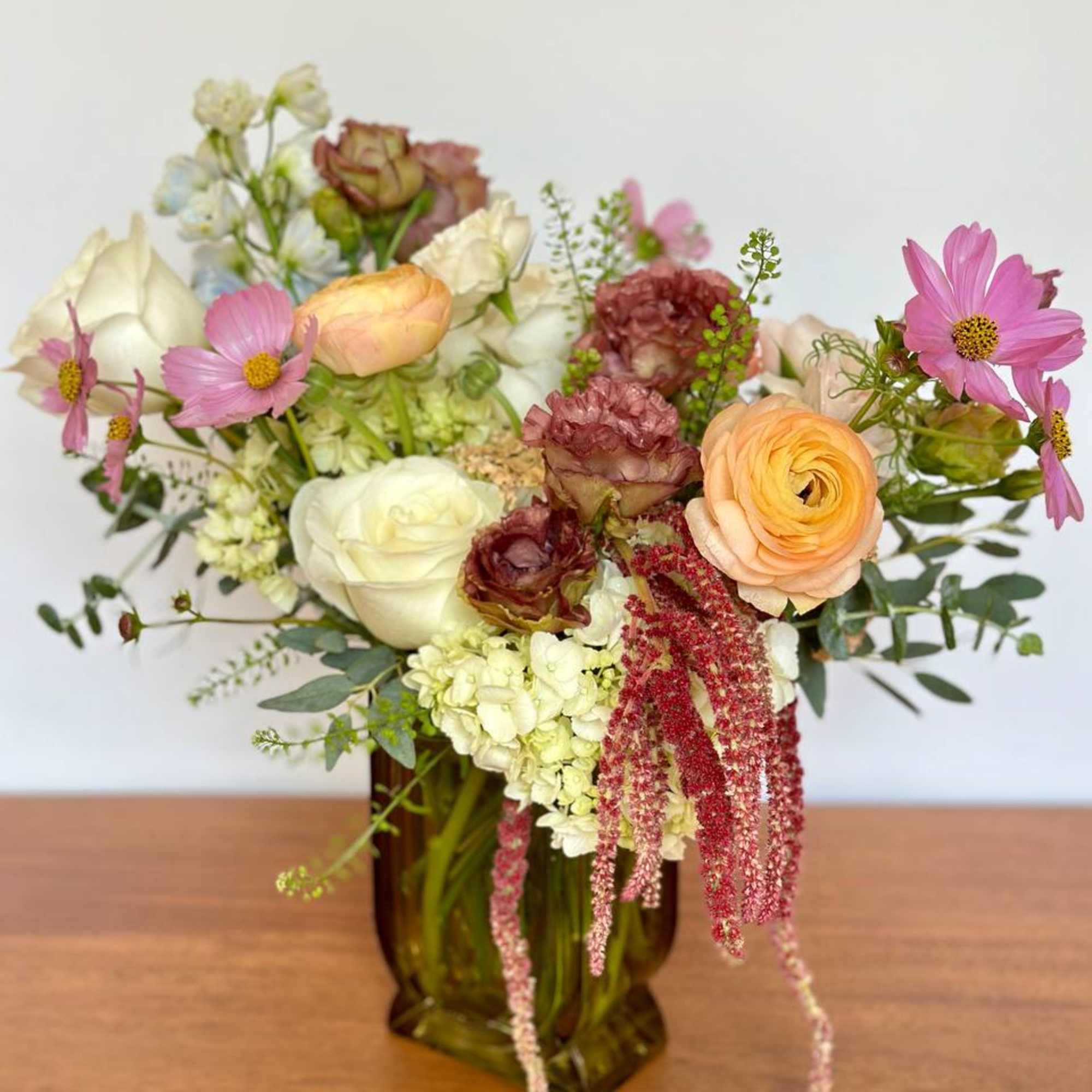 Mixed pastel bouquet in an amber glass vase