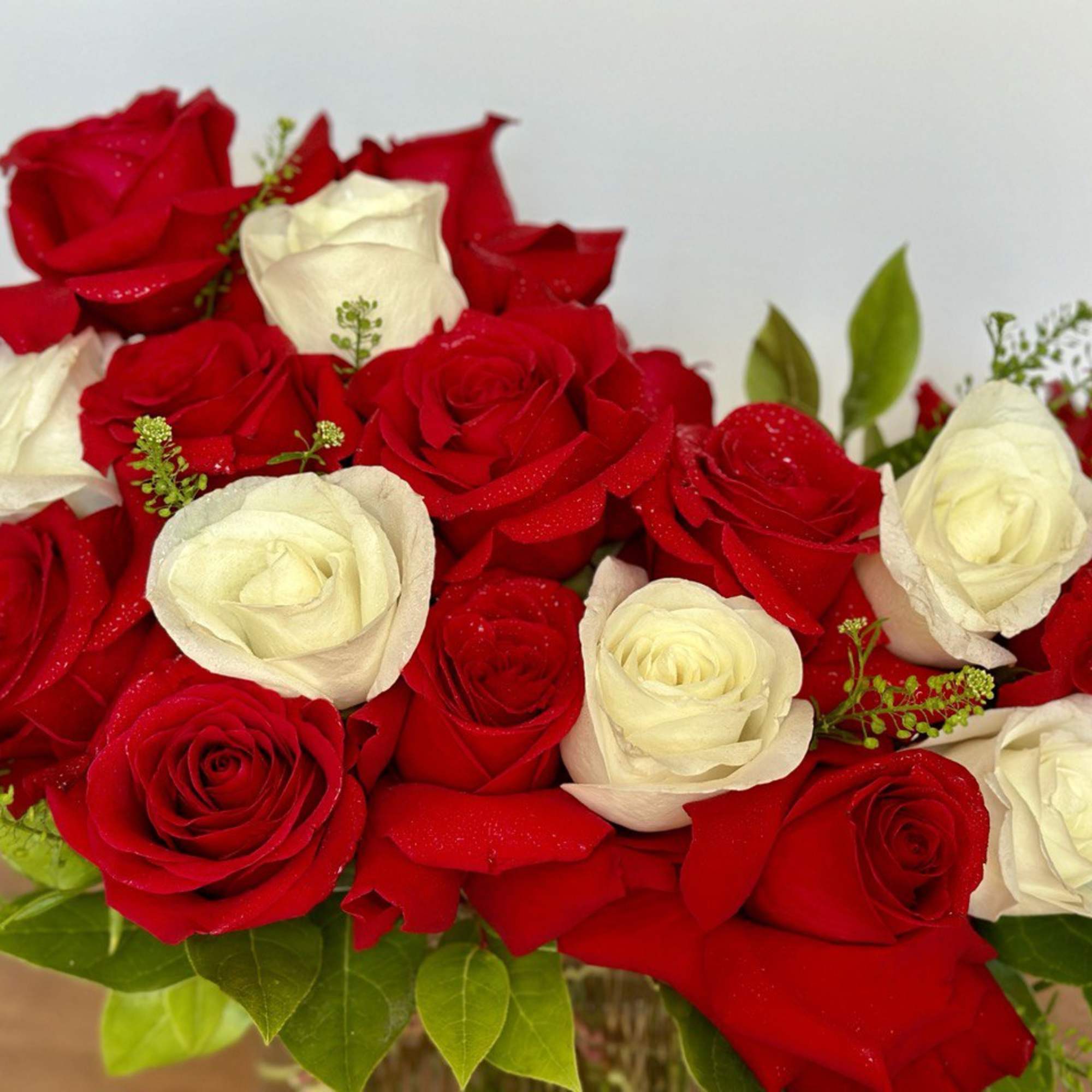 Bouquet of red and white roses with greenery