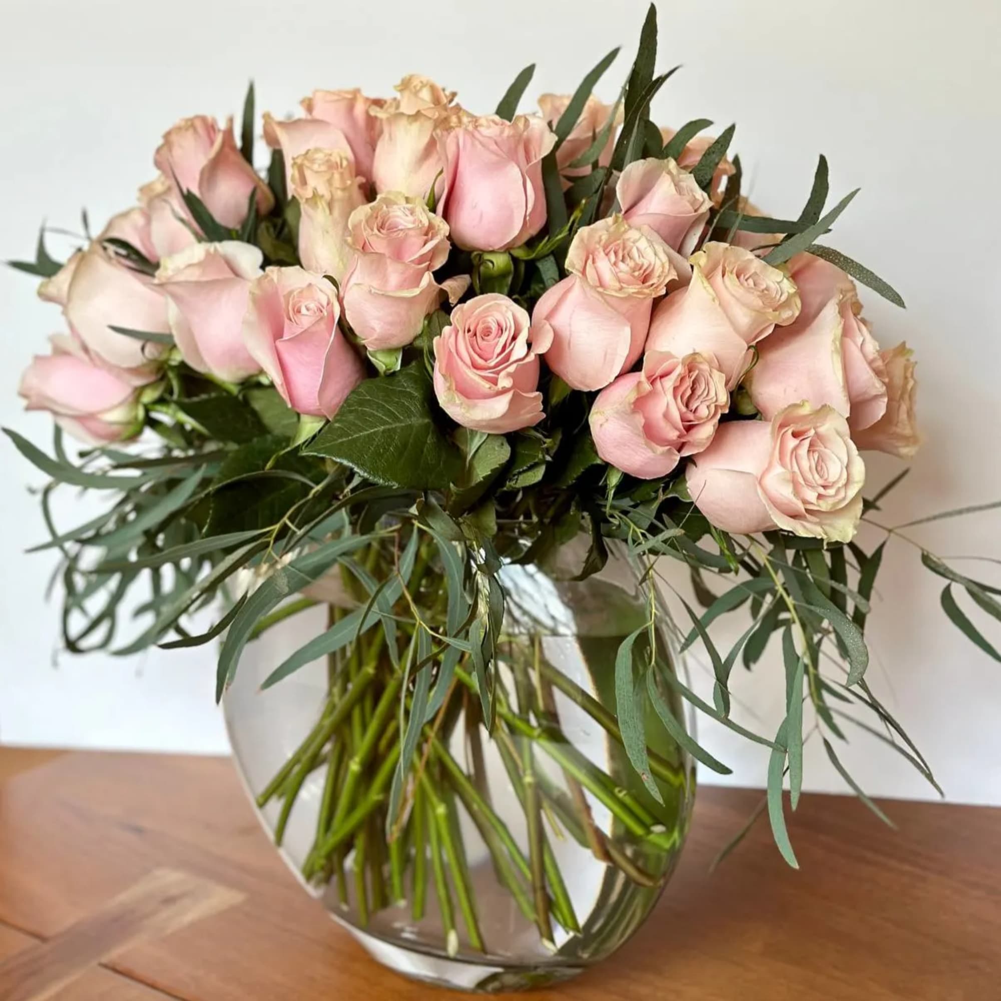 Bouquet of pale pink roses in a clear glass vase