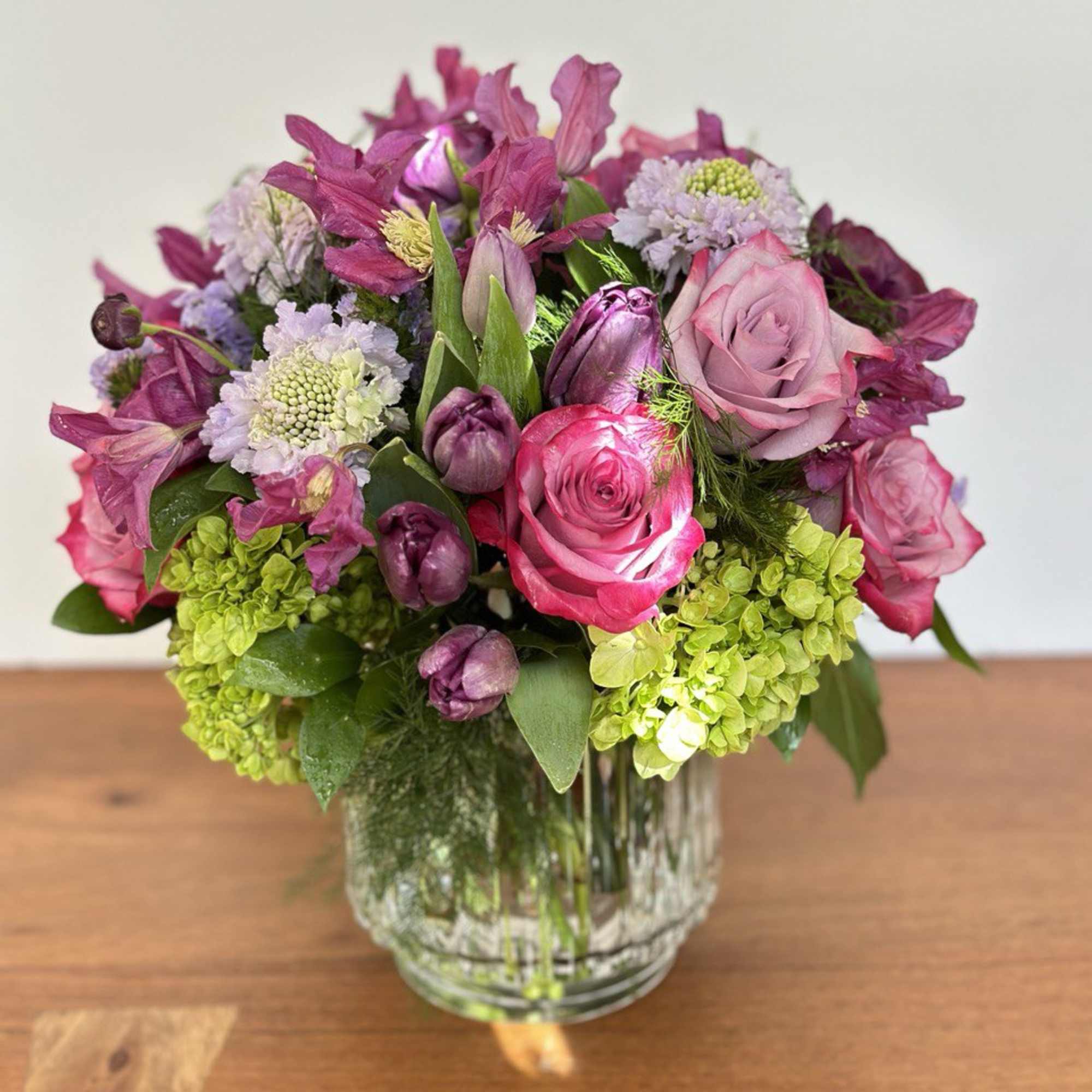 Pink and purple flower arrangement in a clear glass vase