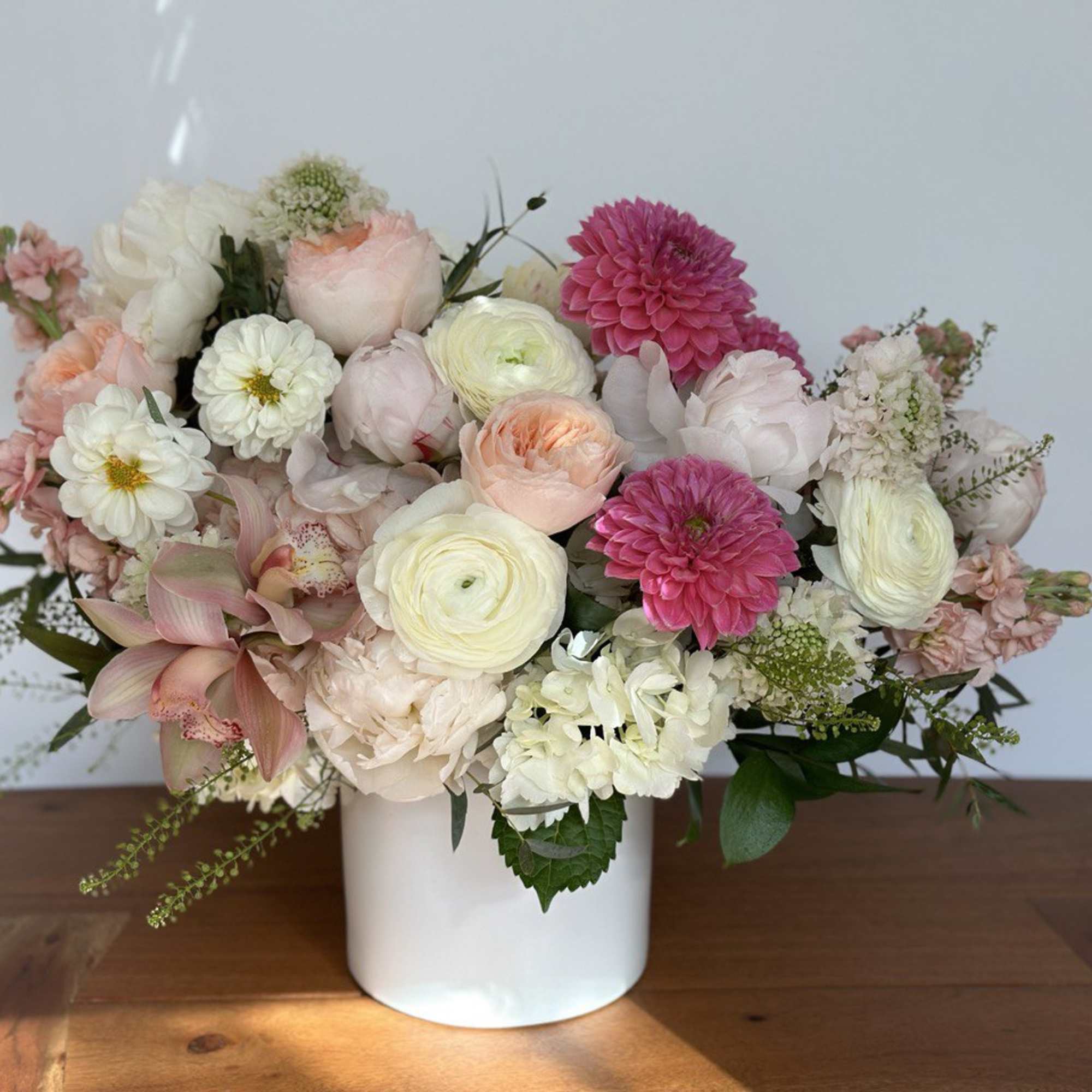Mixed pastel flower arrangement in a white vase