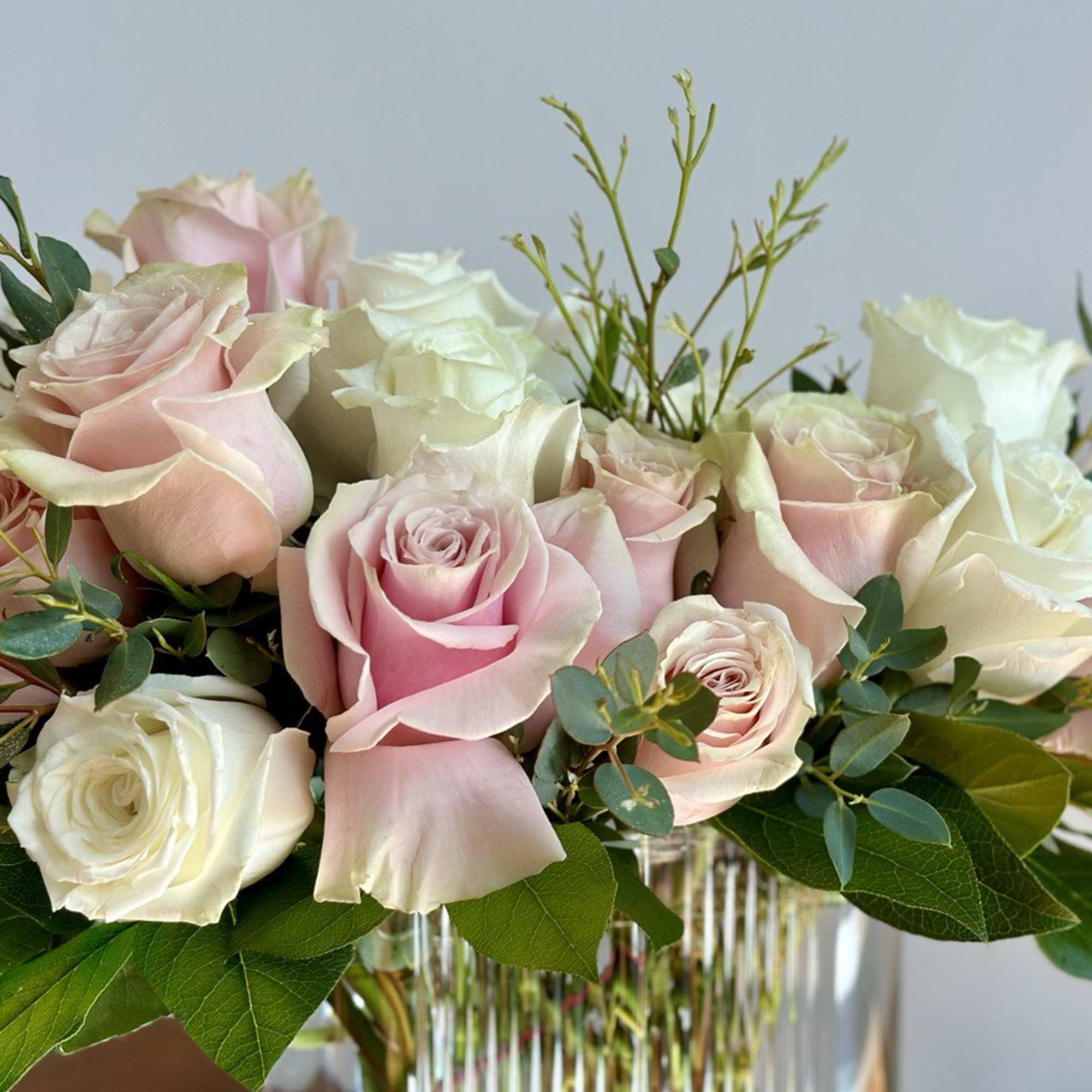 Pink and white roses arranged in a clear glass vase, photo 3 of 3