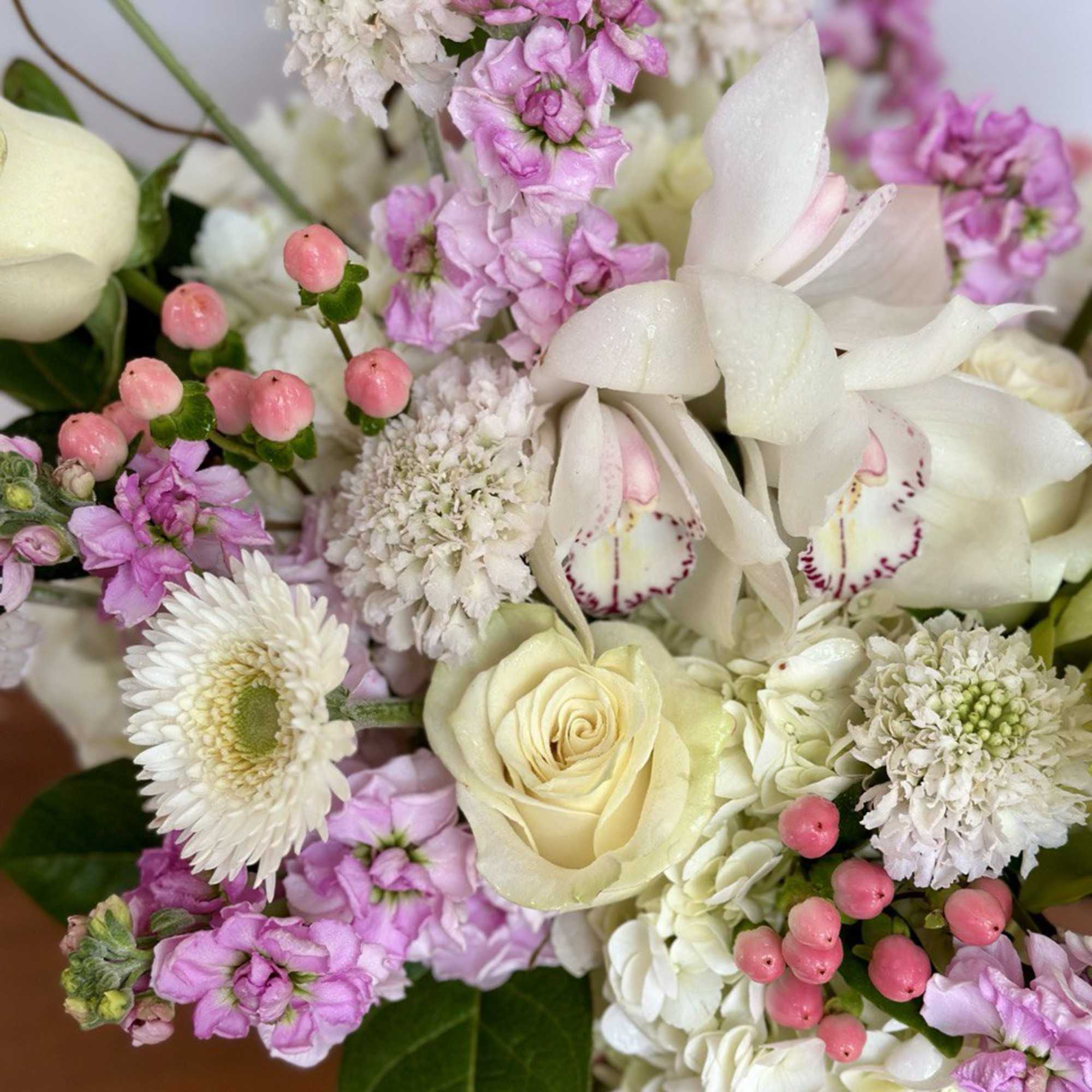 Bouquet of white and pink flowers with a cream rose and orchid blooms