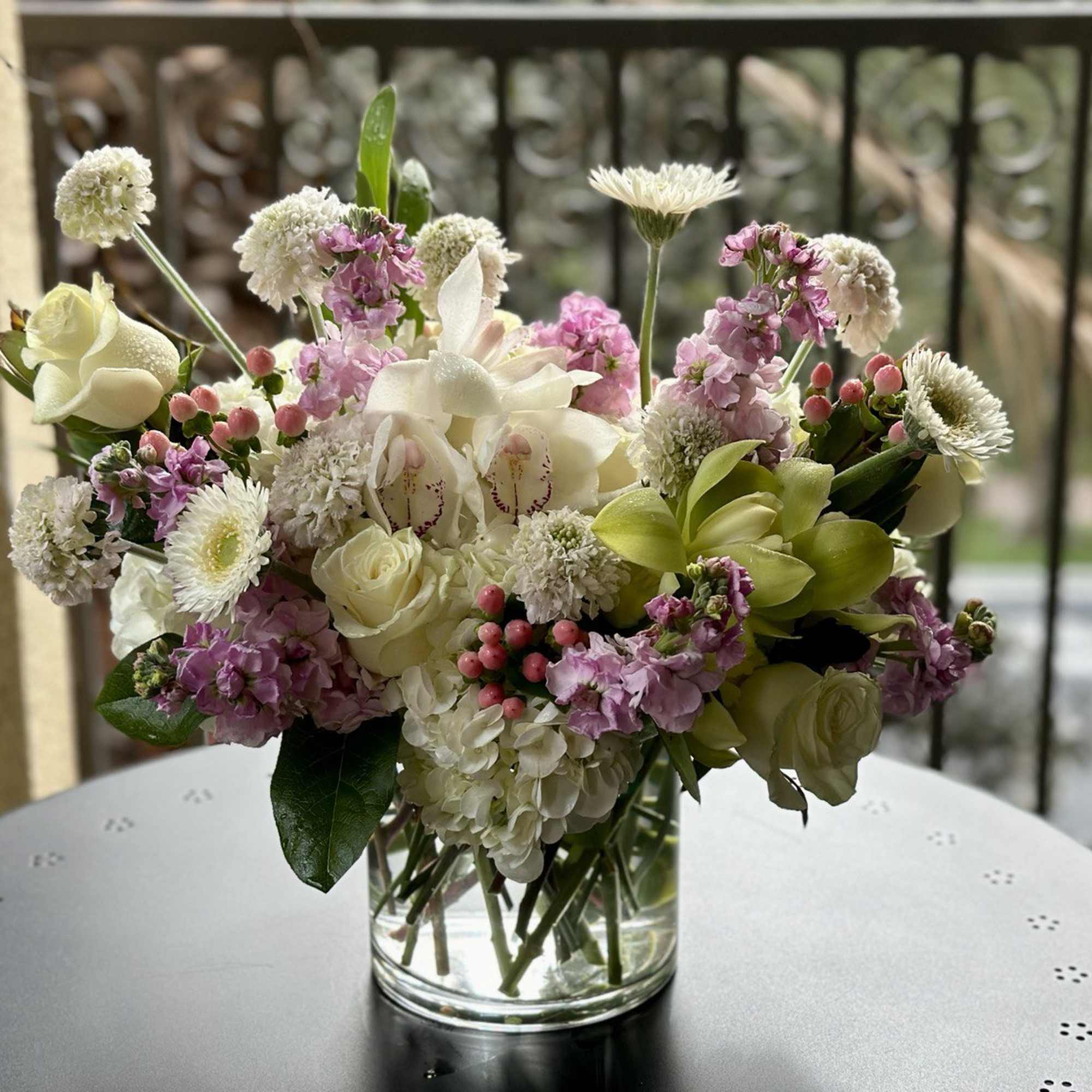 Mixed bouquet of white and pink flowers in a clear glass vase