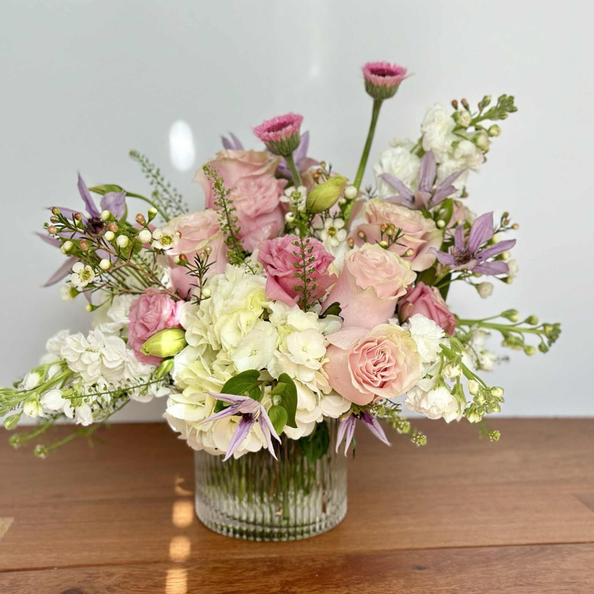 Pink and white floral arrangement in a clear glass vase