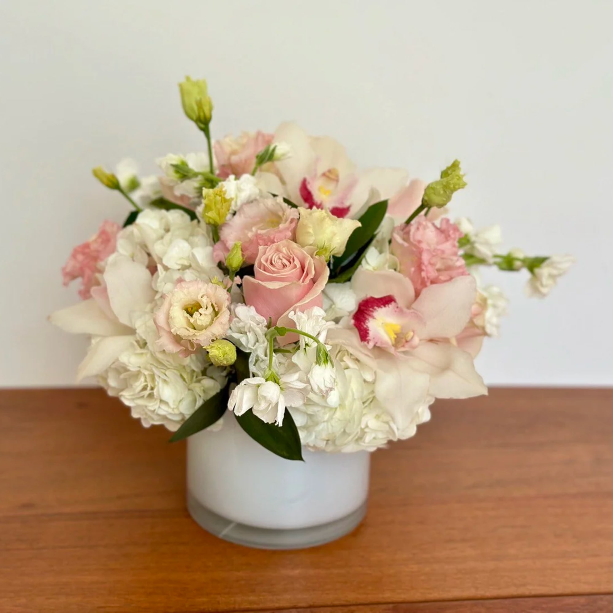 Pink and white floral arrangement in a white vase