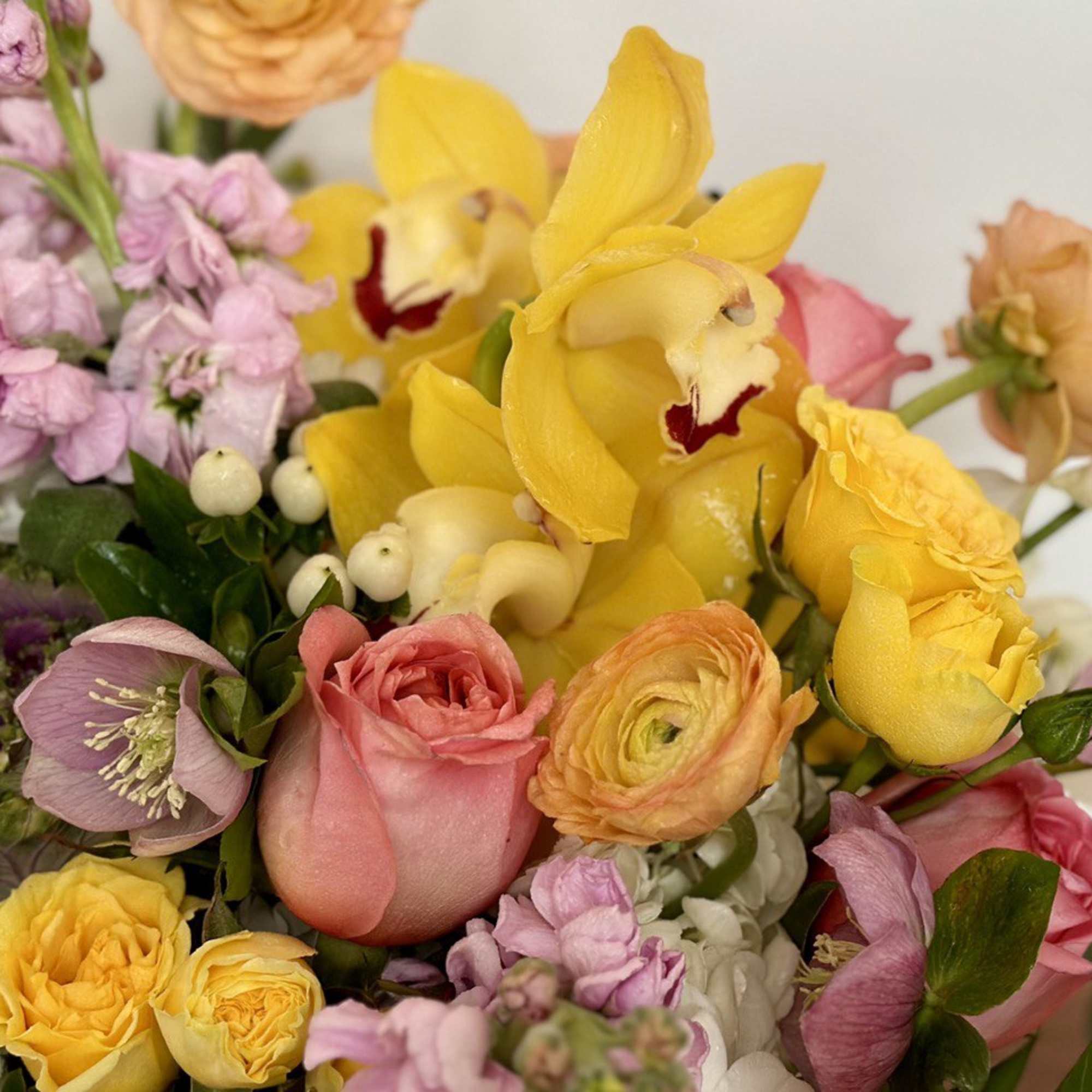 Mixed bouquet with yellow orchids, pink roses, and lavender flowers