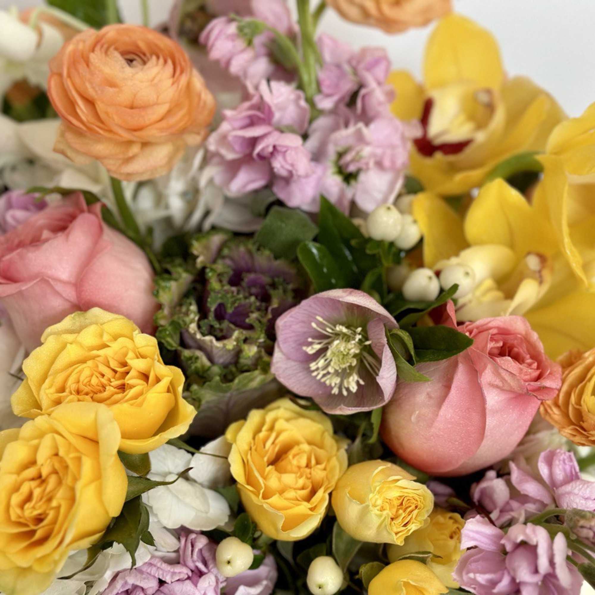 Mixed bouquet with yellow and pink roses, ranunculus, and lilac flowers