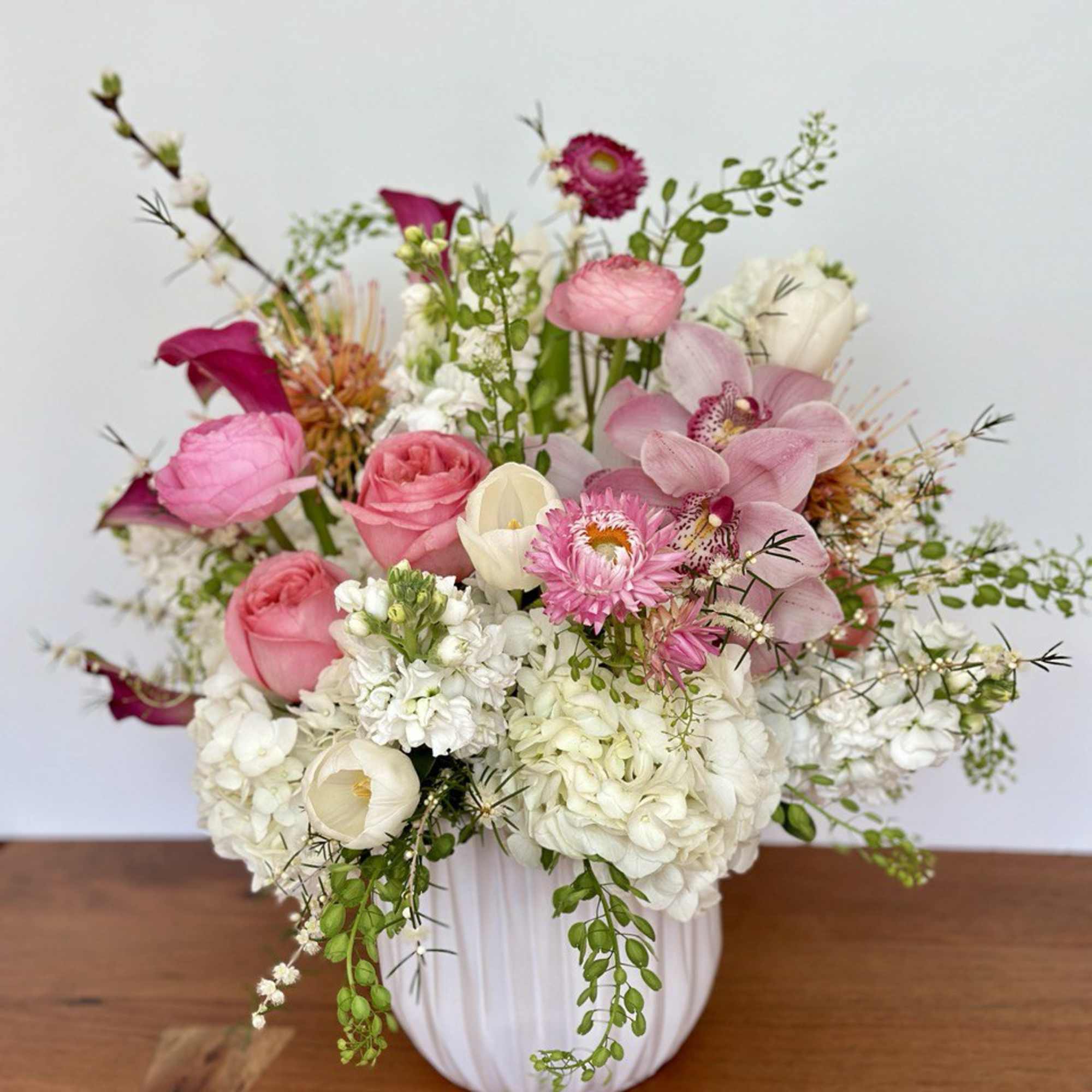 Pink and white mixed flower arrangement in a white vase