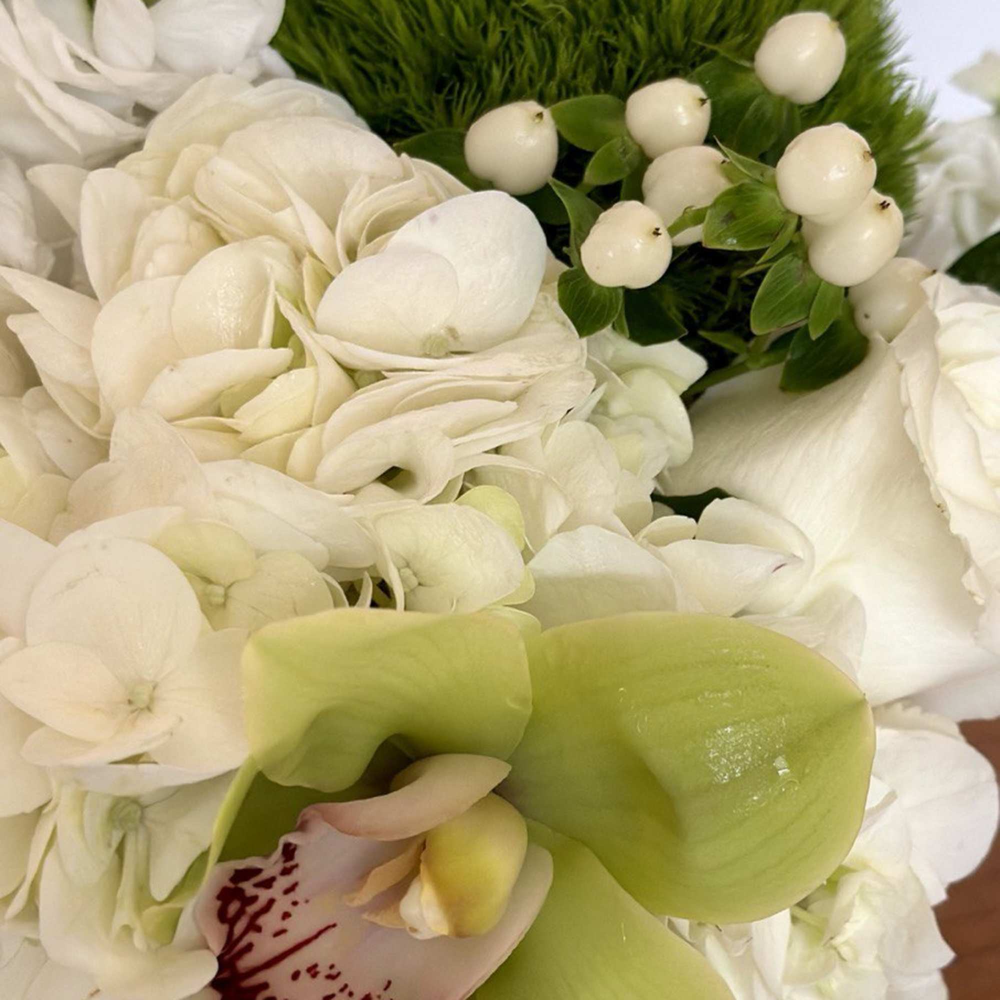 White hydrangea bouquet with green orchids and berries