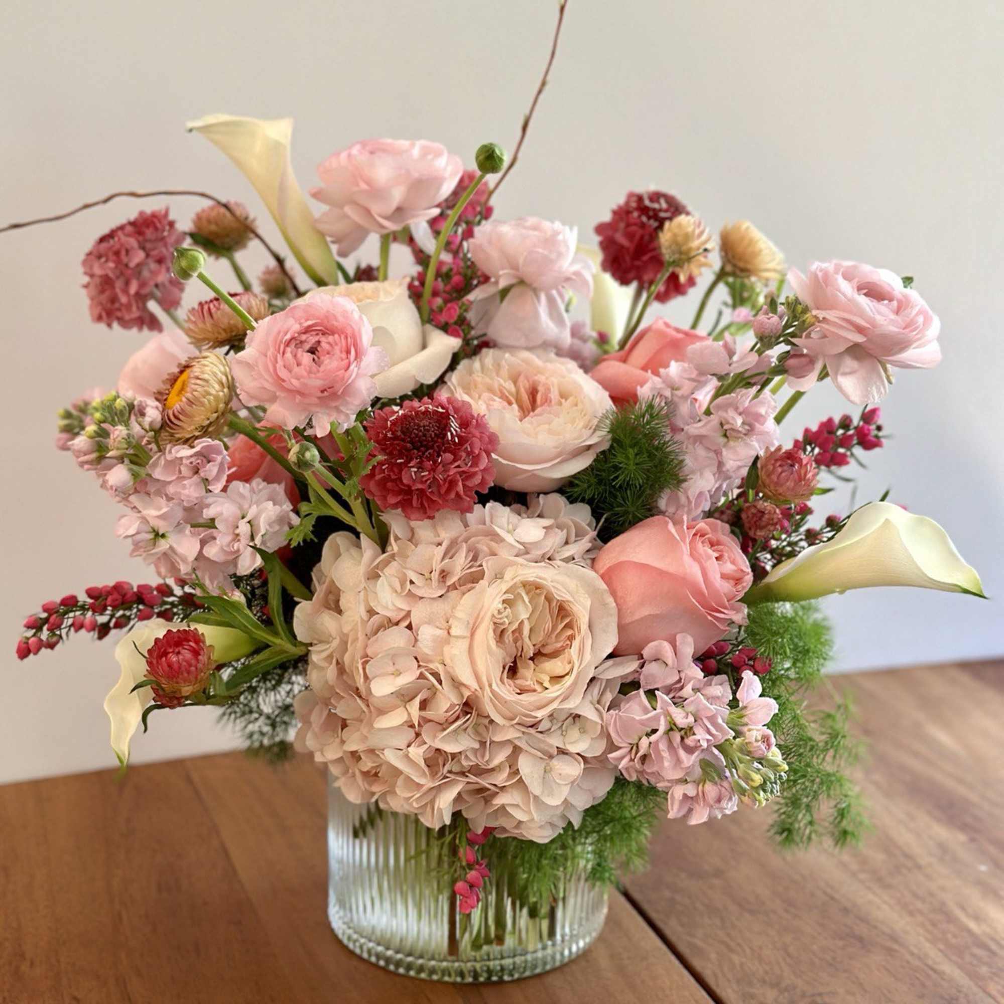 Pink and cream mixed flower arrangement in a clear glass vase