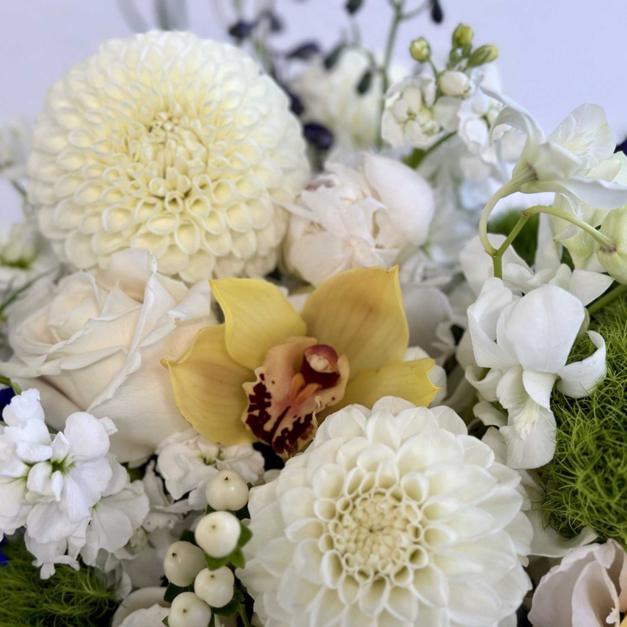 White and yellow floral arrangement with blue accents