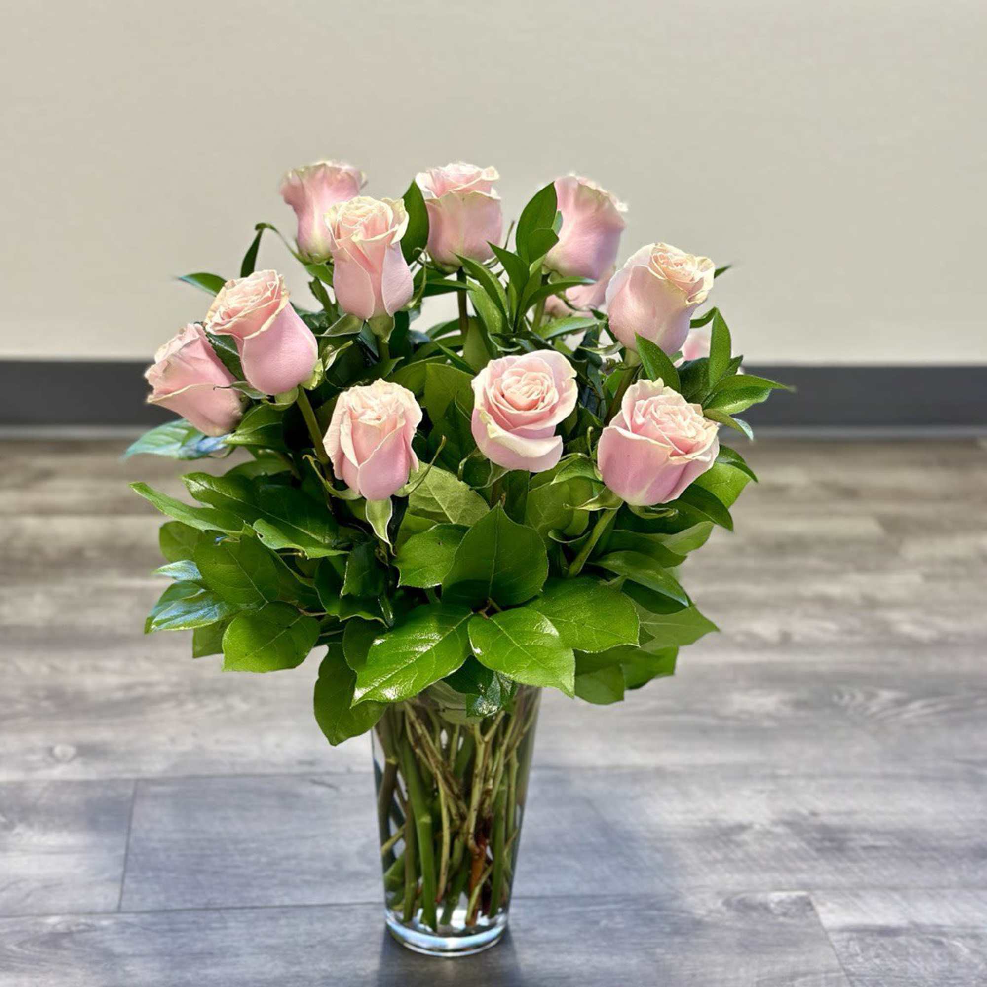 Pink roses arranged in a clear glass vase
