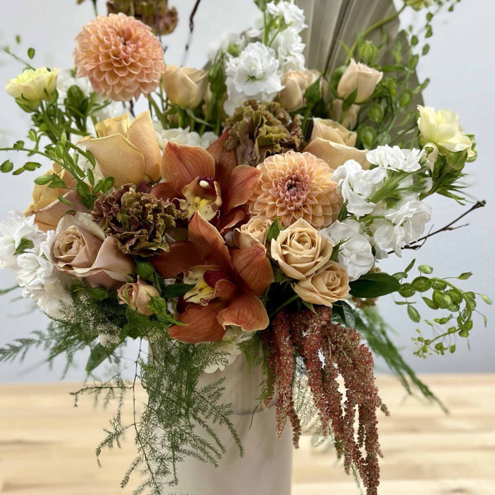 Peach and white mixed bouquet in a white vase