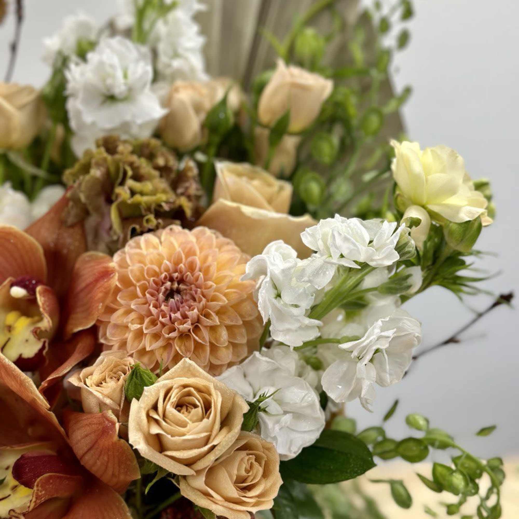 Bouquet of peach roses, white flowers, and orange blooms