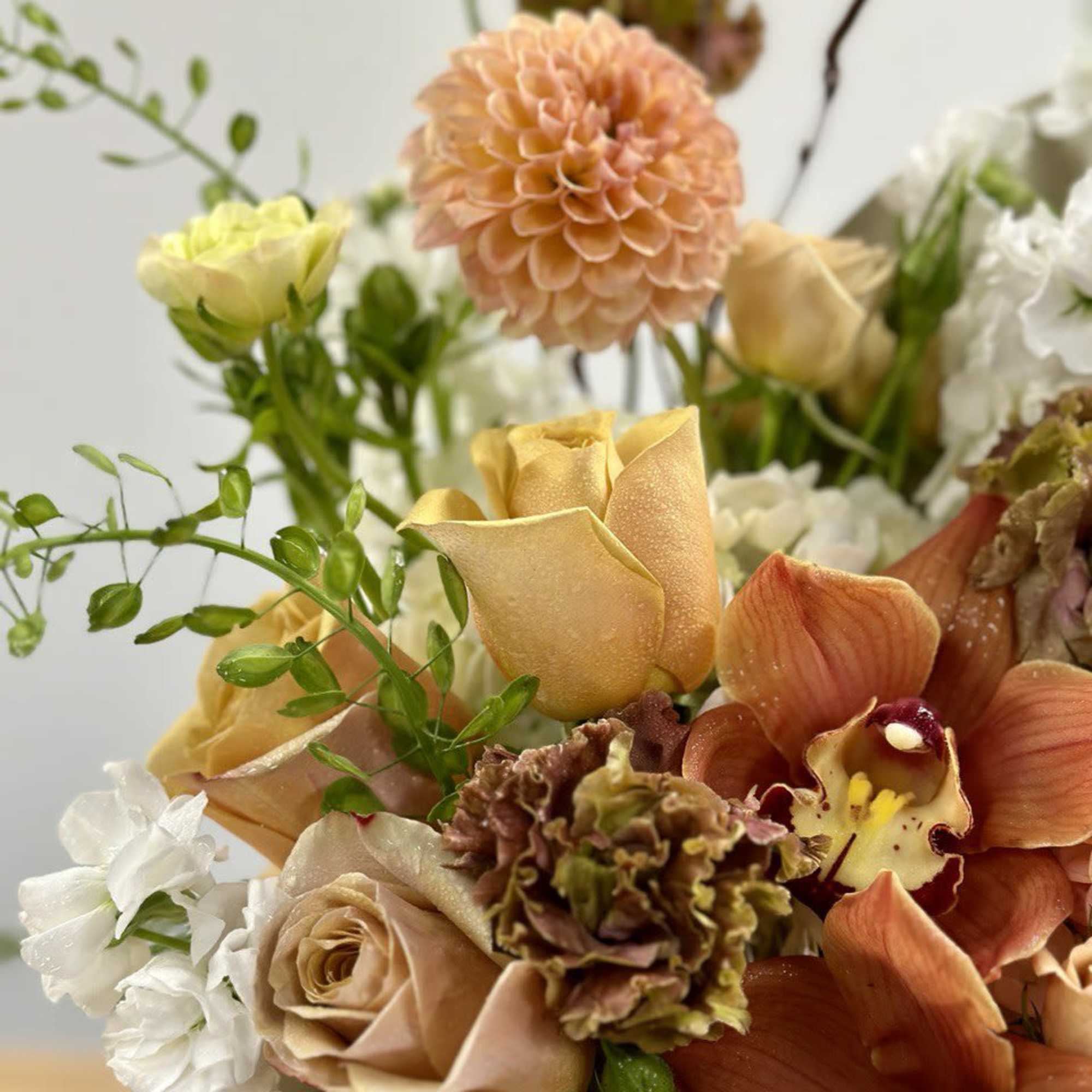 Bouquet of peach, white, and orange flowers with roses and orchids