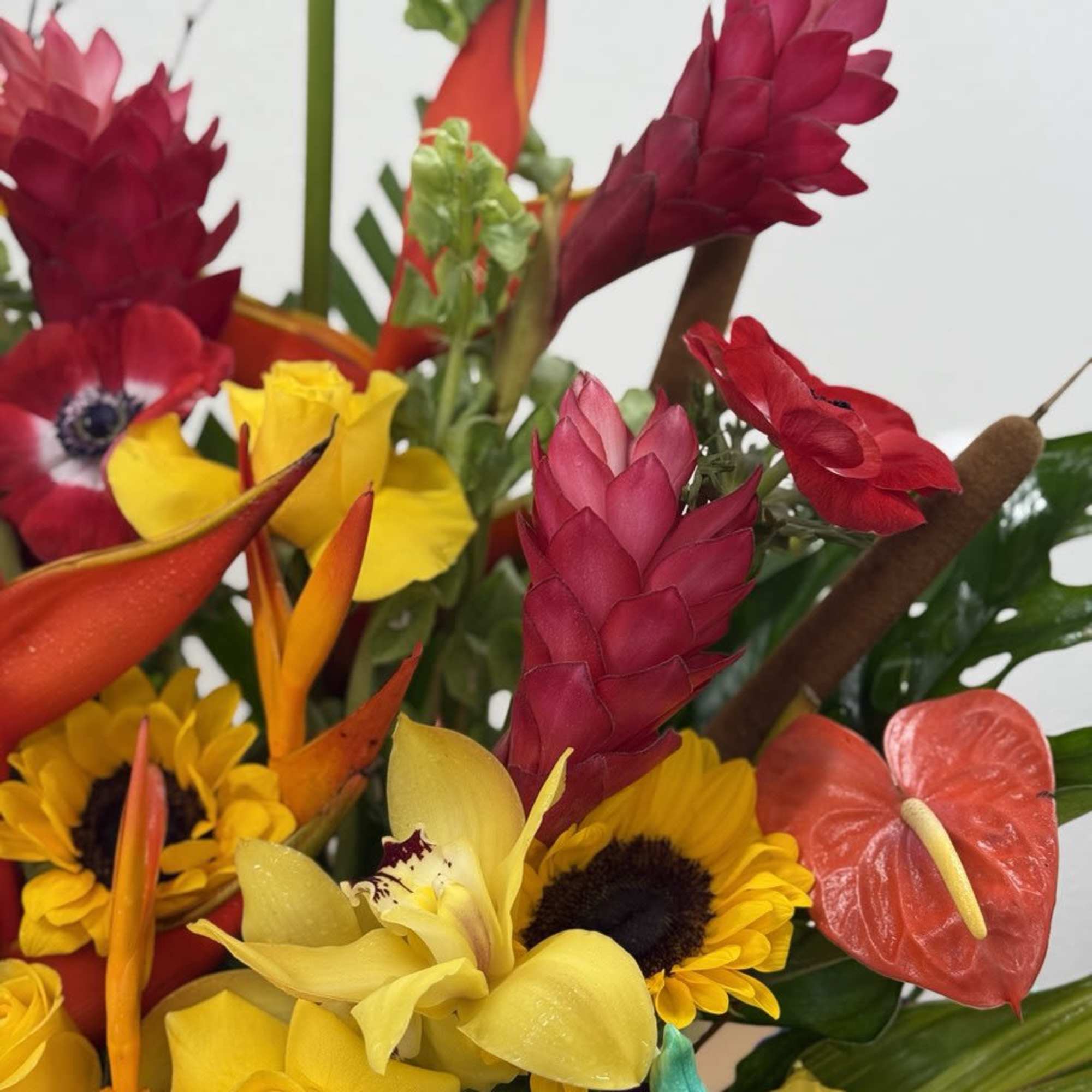 Tropical bouquet with sunflowers, roses, anthuriums, and red ginger blooms