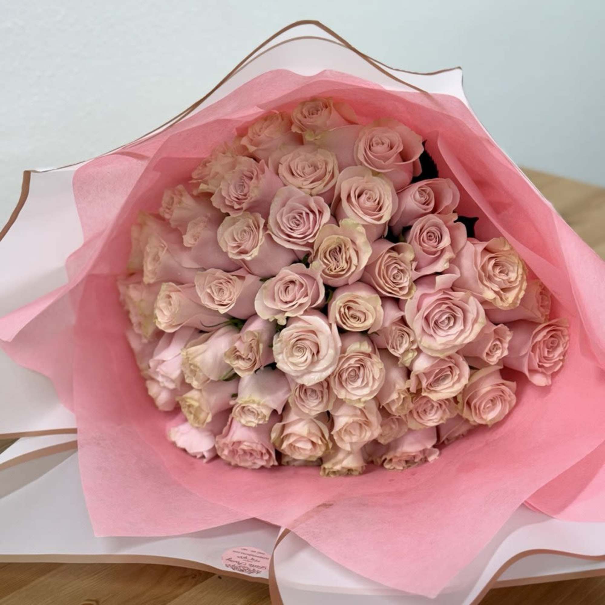 Bouquet of pale pink roses wrapped in pink paper