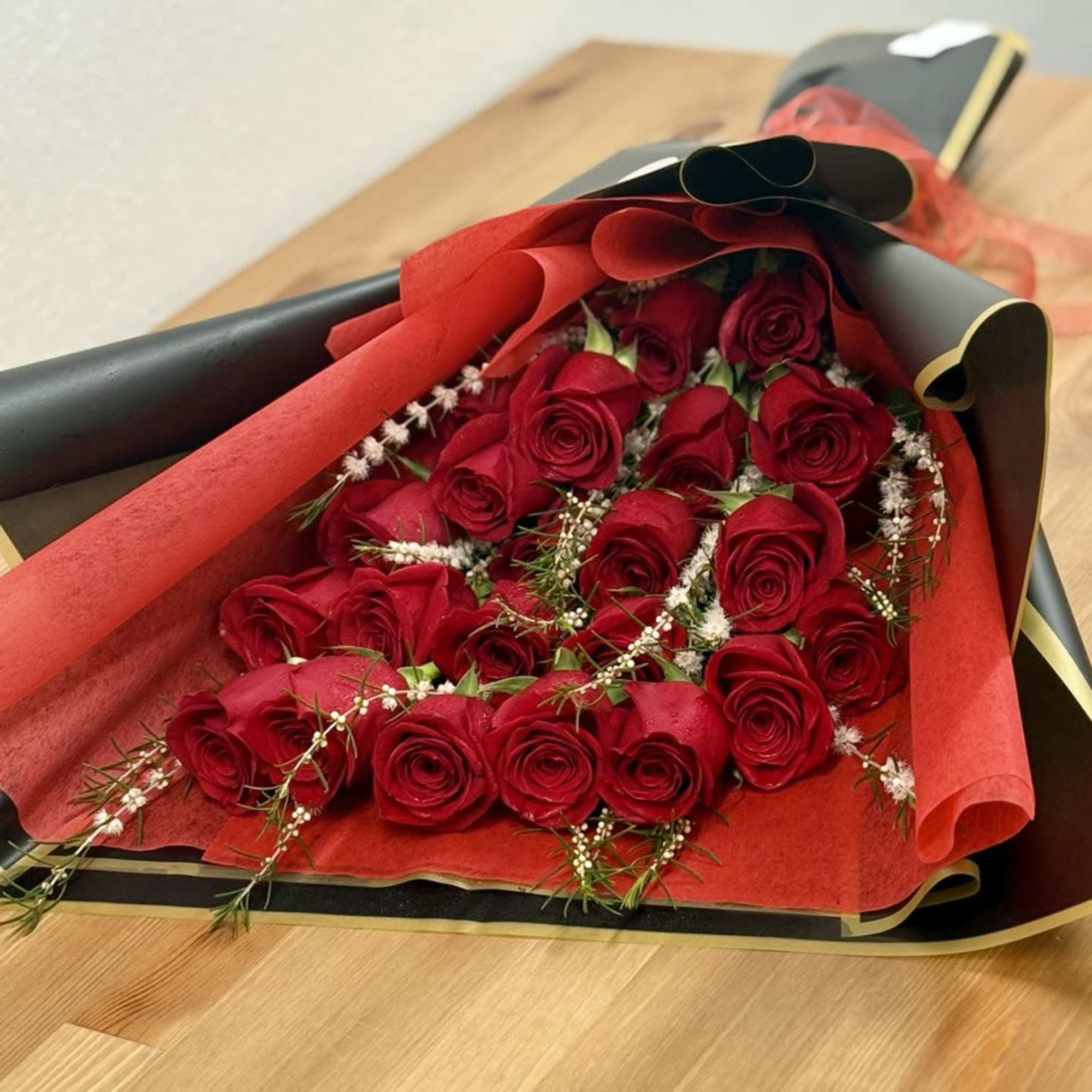 Bouquet of red roses wrapped in black and red paper