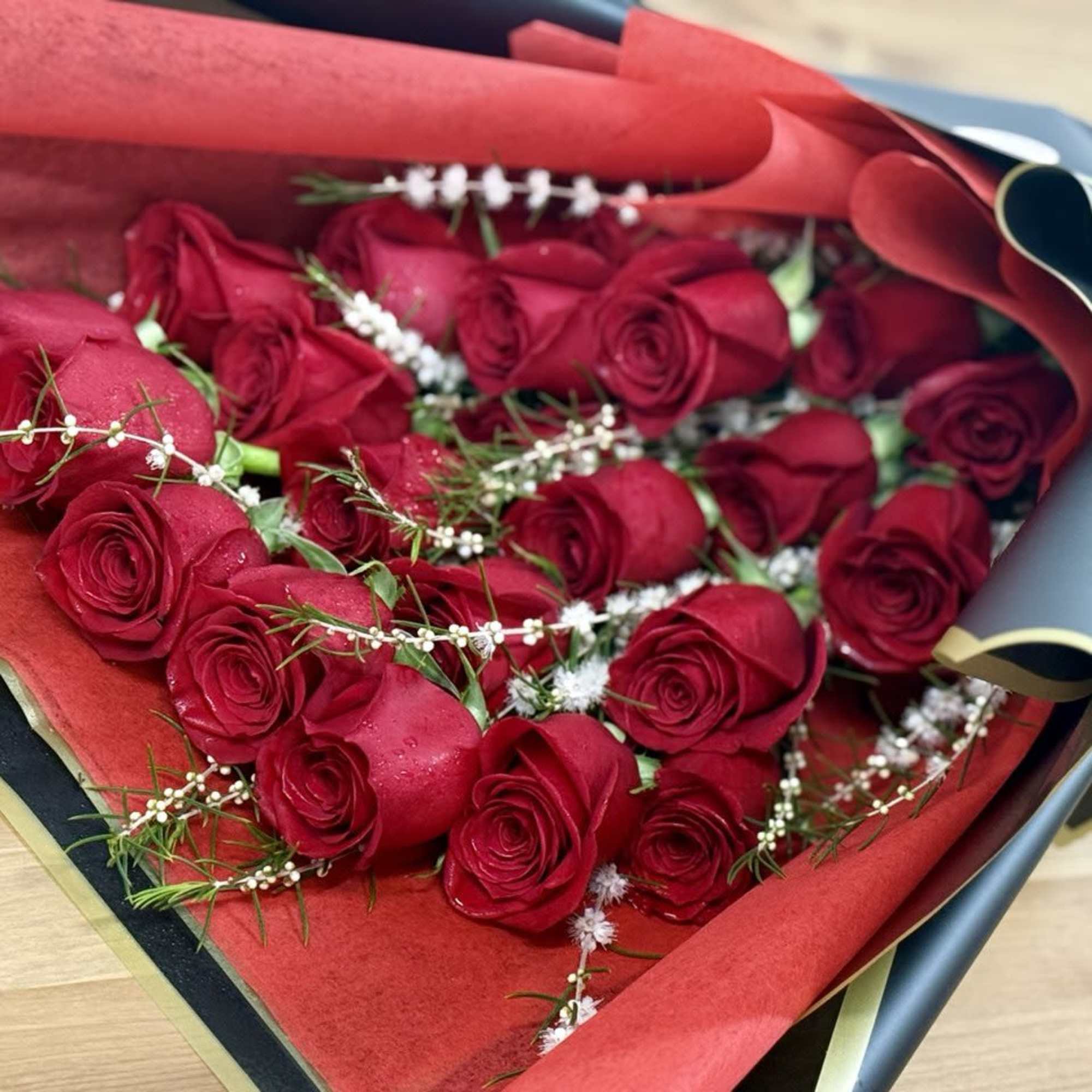 Bouquet of red roses wrapped in red and black paper