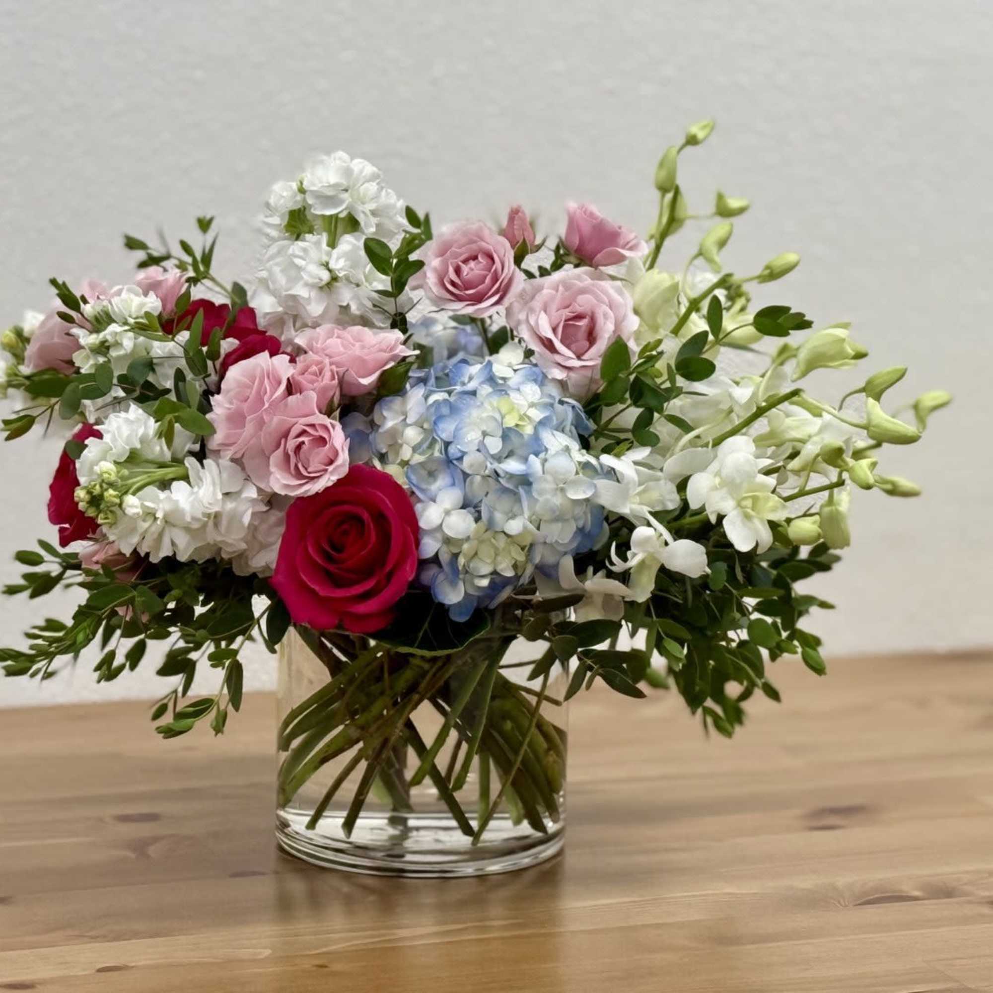 Mixed bouquet of pink and white flowers in a clear glass vase