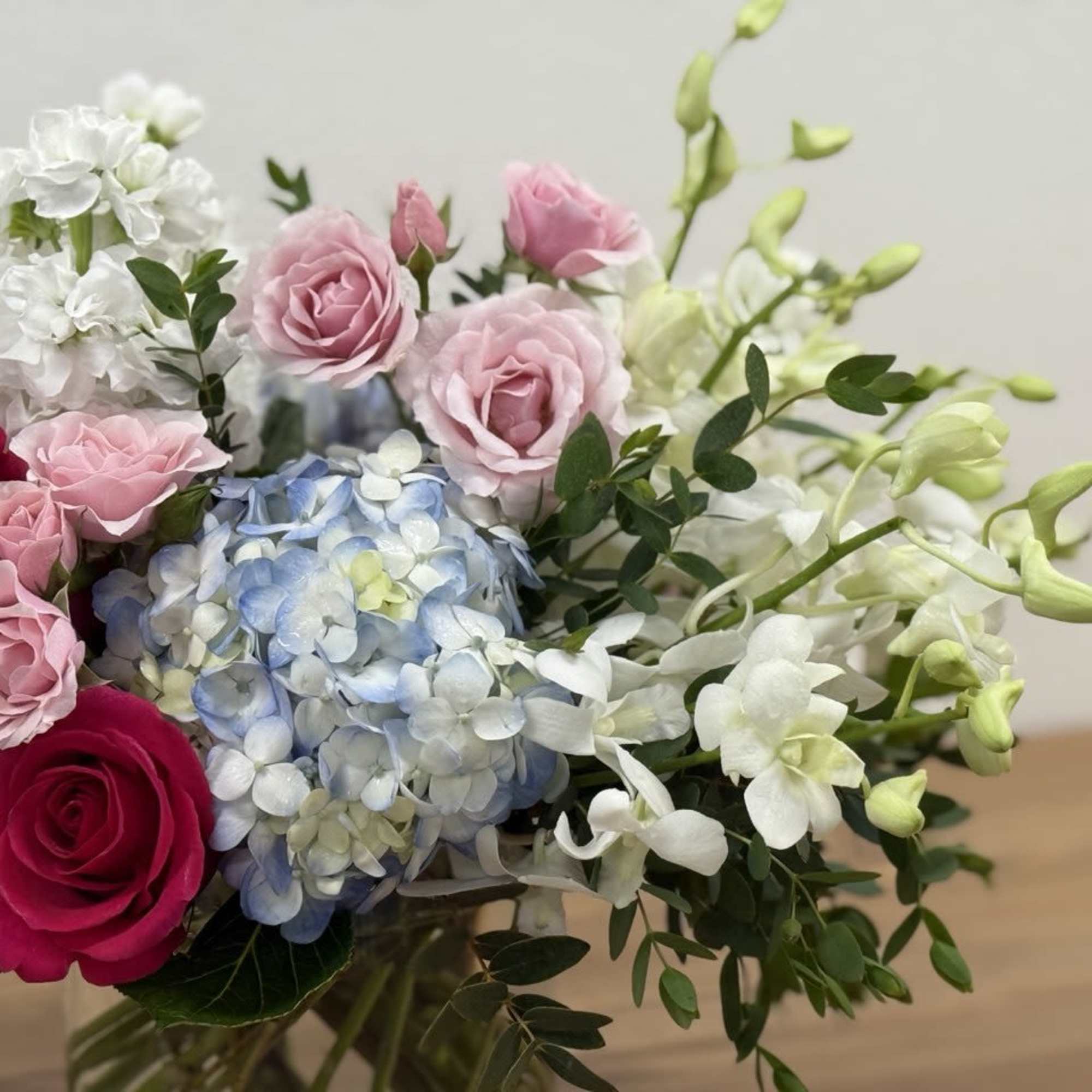 Bouquet of pink and white roses with blue hydrangea and white orchids