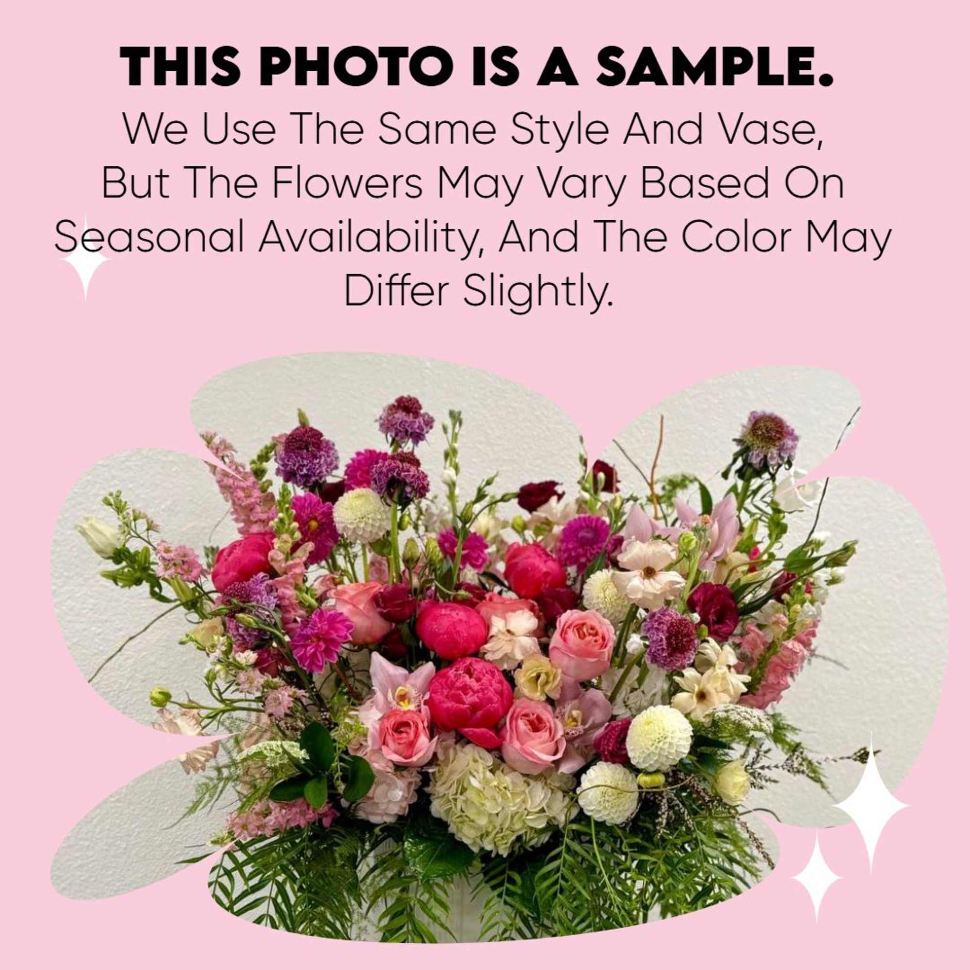 Lush arrangement of pink and white blooms with fuchsia peonies and roses in a mixed garden style