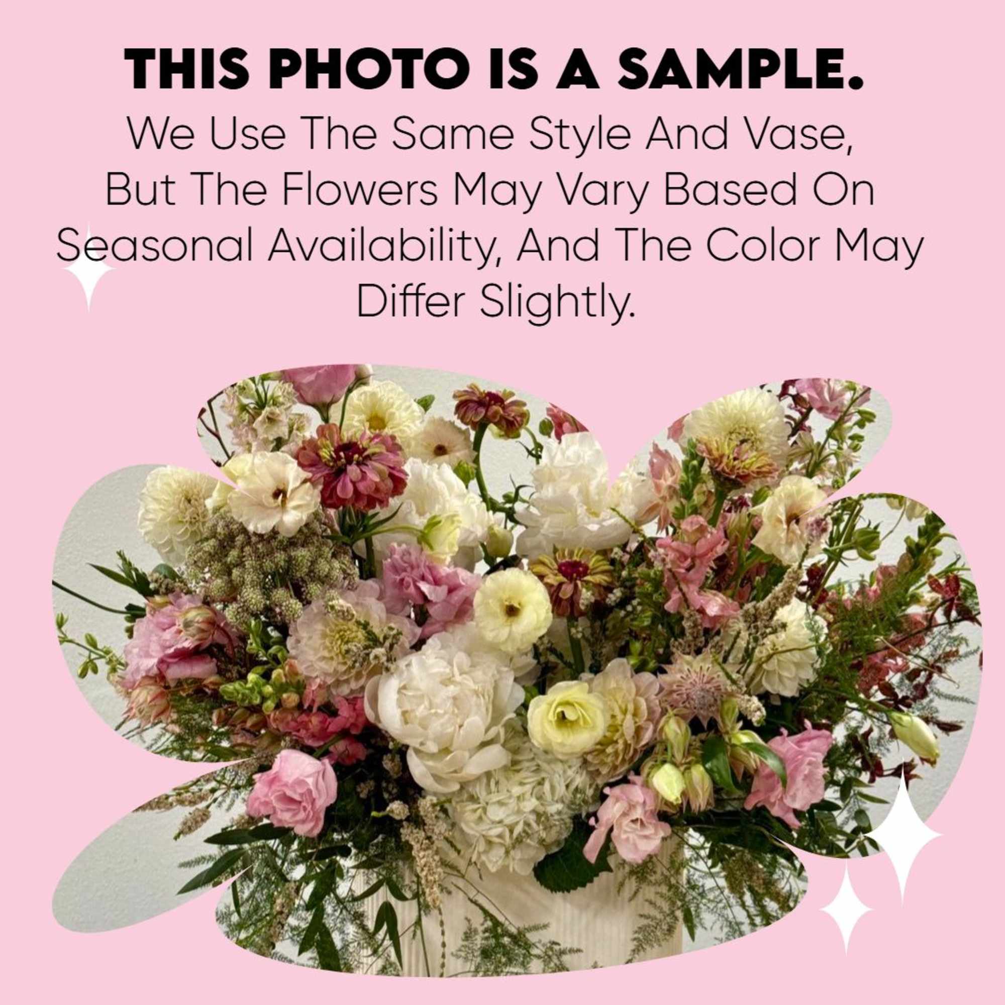 Lush pink, white, and cream mixed flower arrangement in a white vase with text indicating it is a sample.