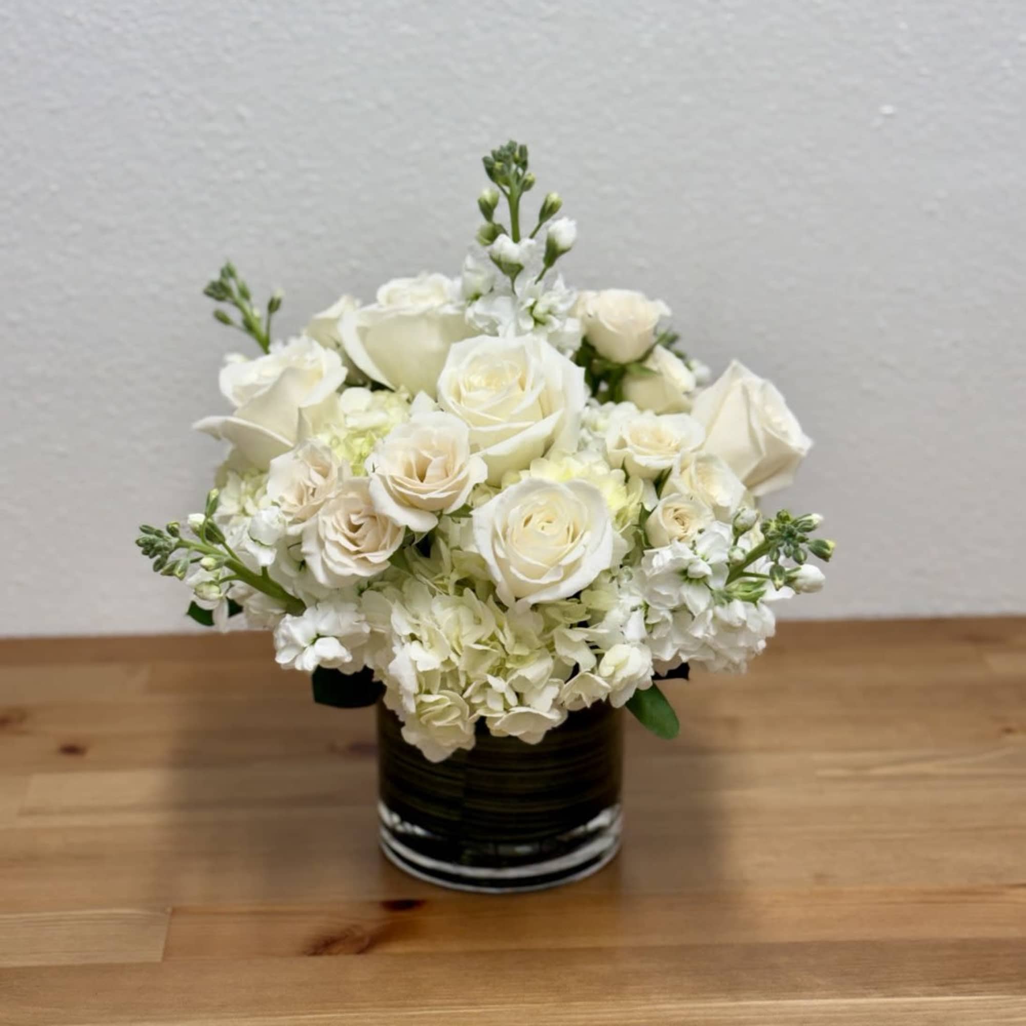 White rose bouquet in a dark glass vase