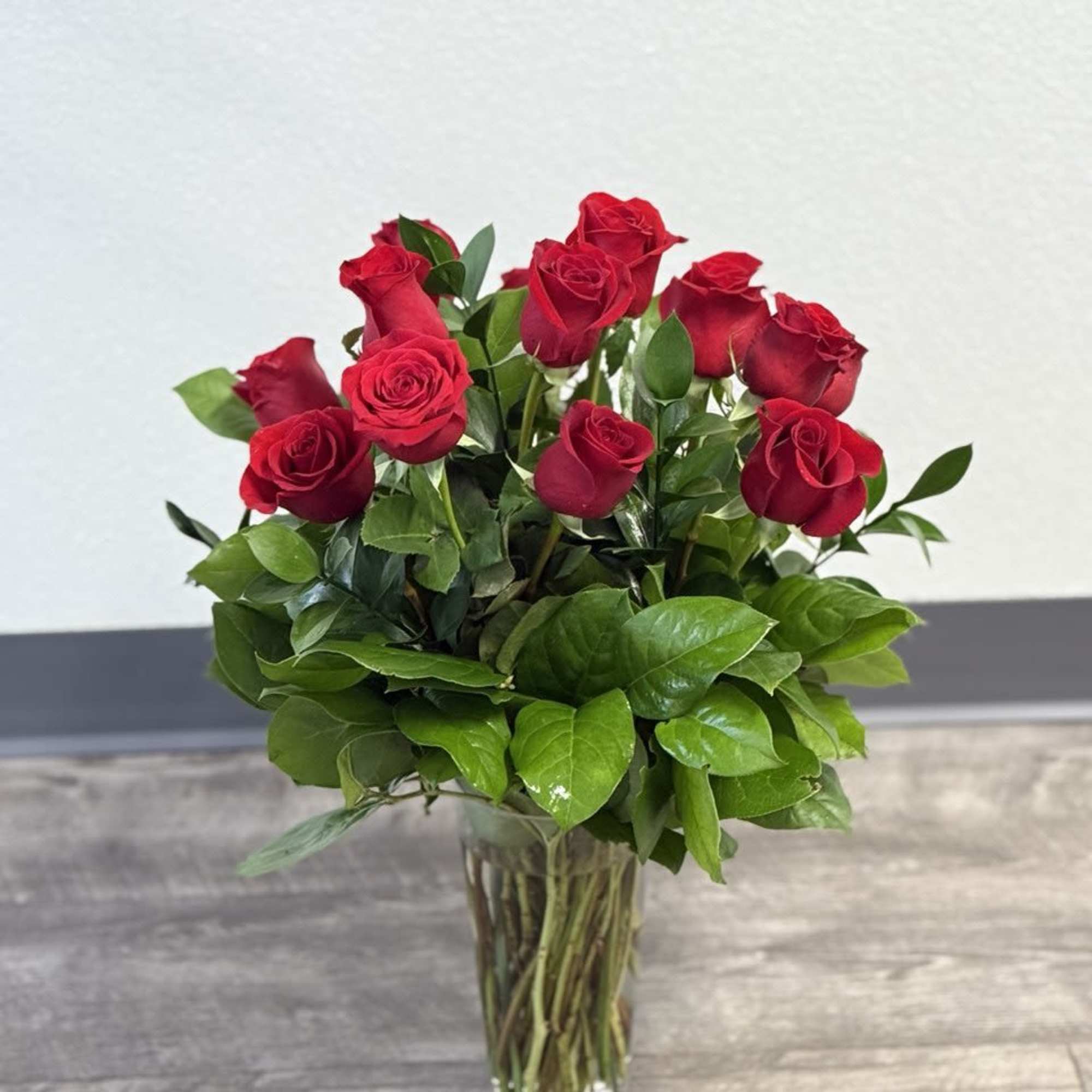 Red roses arranged in a clear glass vase